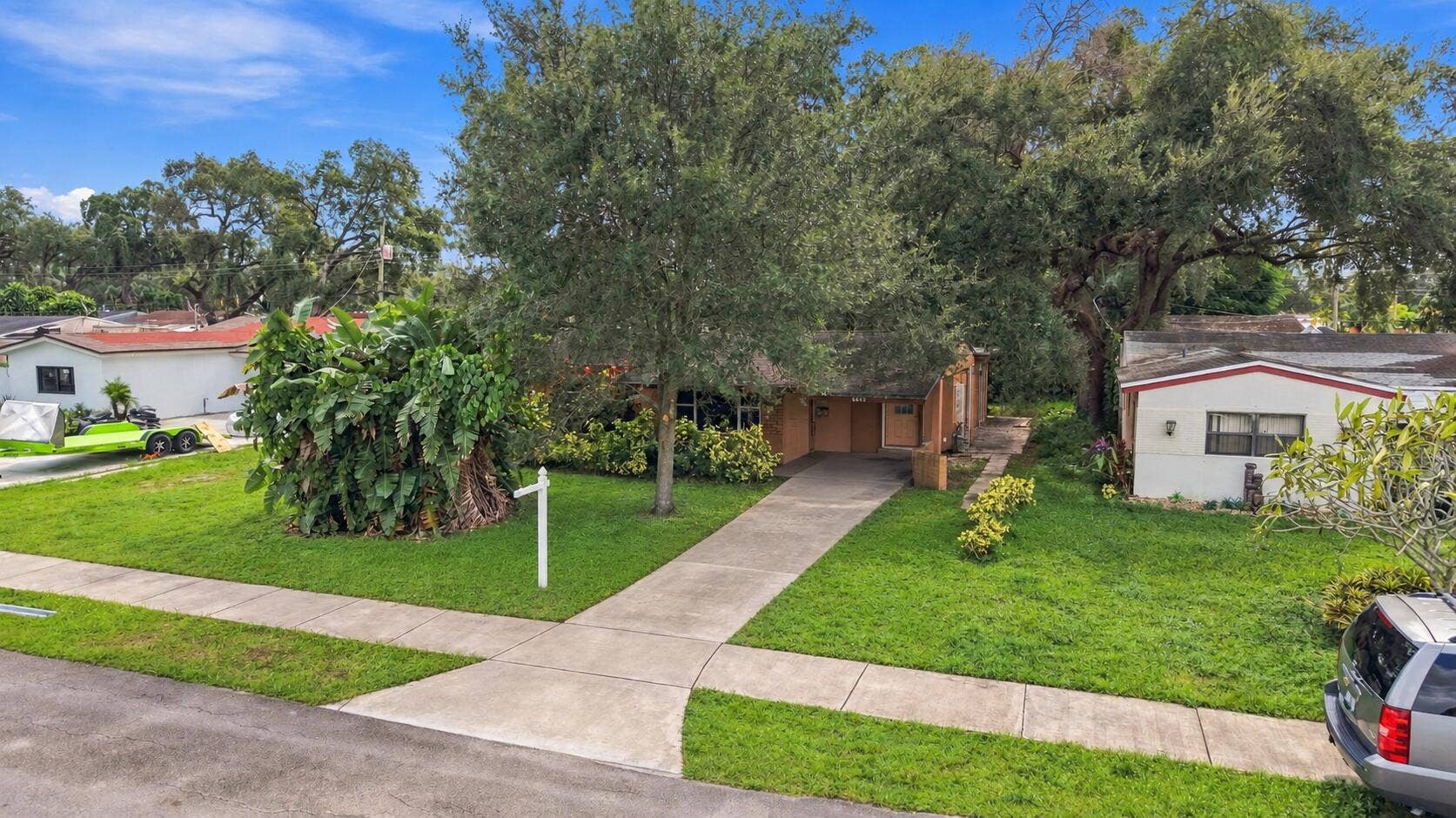 6660 FREEDOM Street, Hollywood, FL 33024 Exterior featuring a concrete walkway, mature trees, and landscaping