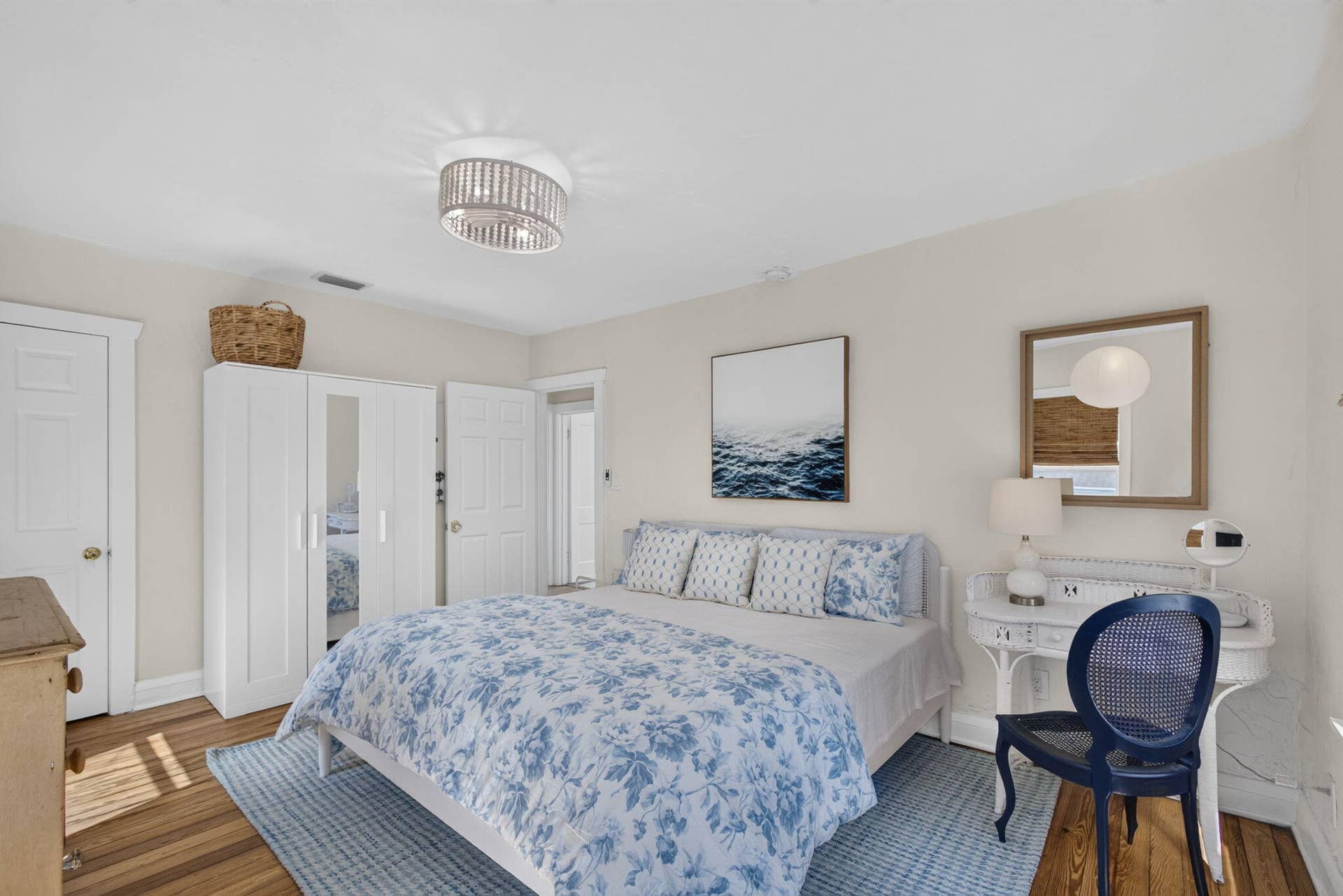 Bedroom featuring wood-finish flooring, a drum-style ceiling light fixture, and classic white interior doors