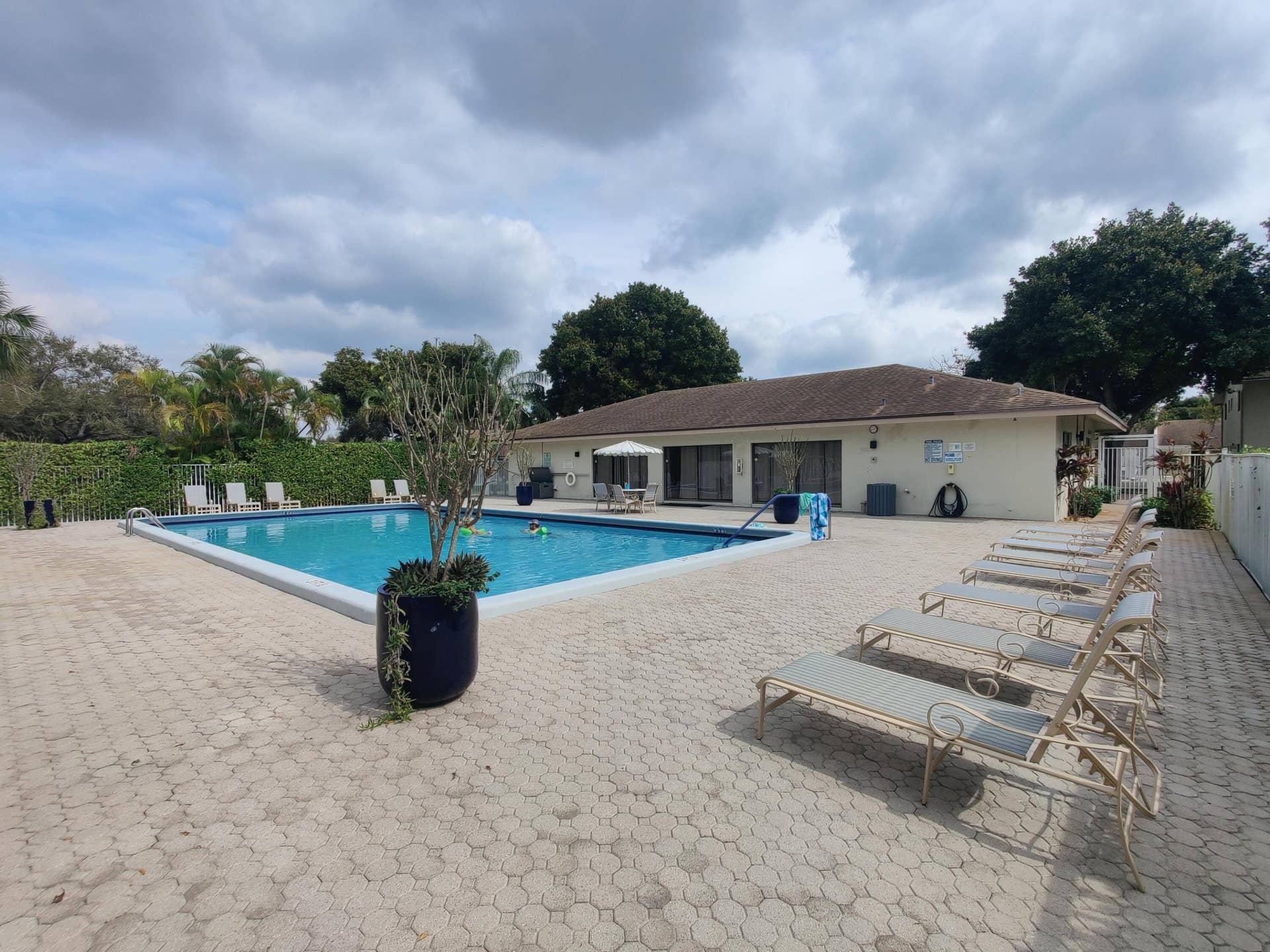2700 S OAKLAND FOREST Drive, #603, Oakland Park, FL 33309 In-ground swimming pool with a concrete paver deck and perimeter privacy hedging