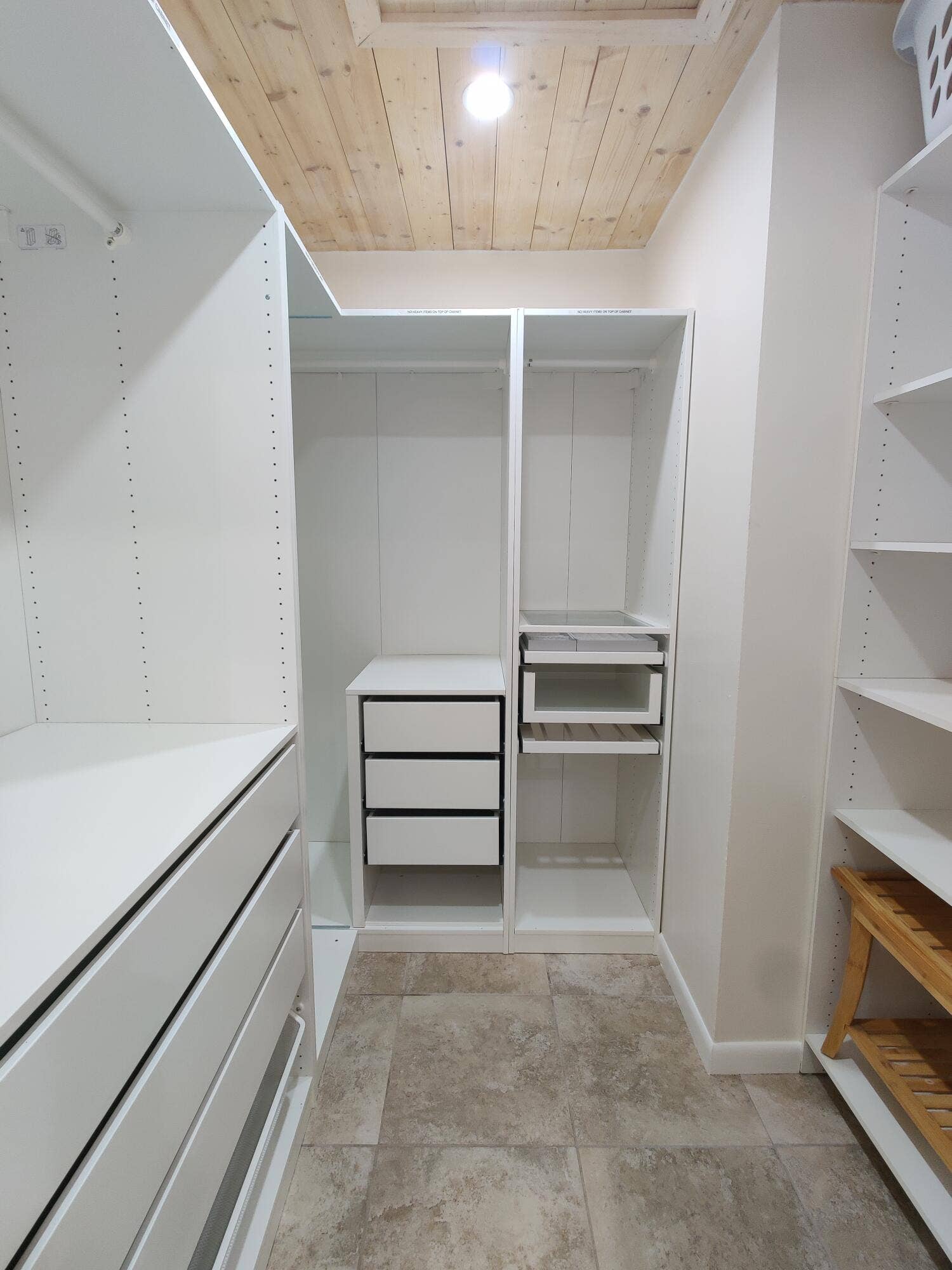 2700 S OAKLAND FOREST Drive, #603, Oakland Park, FL 33309 Walk-in closet featuring custom white cabinetry with integrated drawer storage, open shelving, tile flooring, and a natural wood-plank ceiling