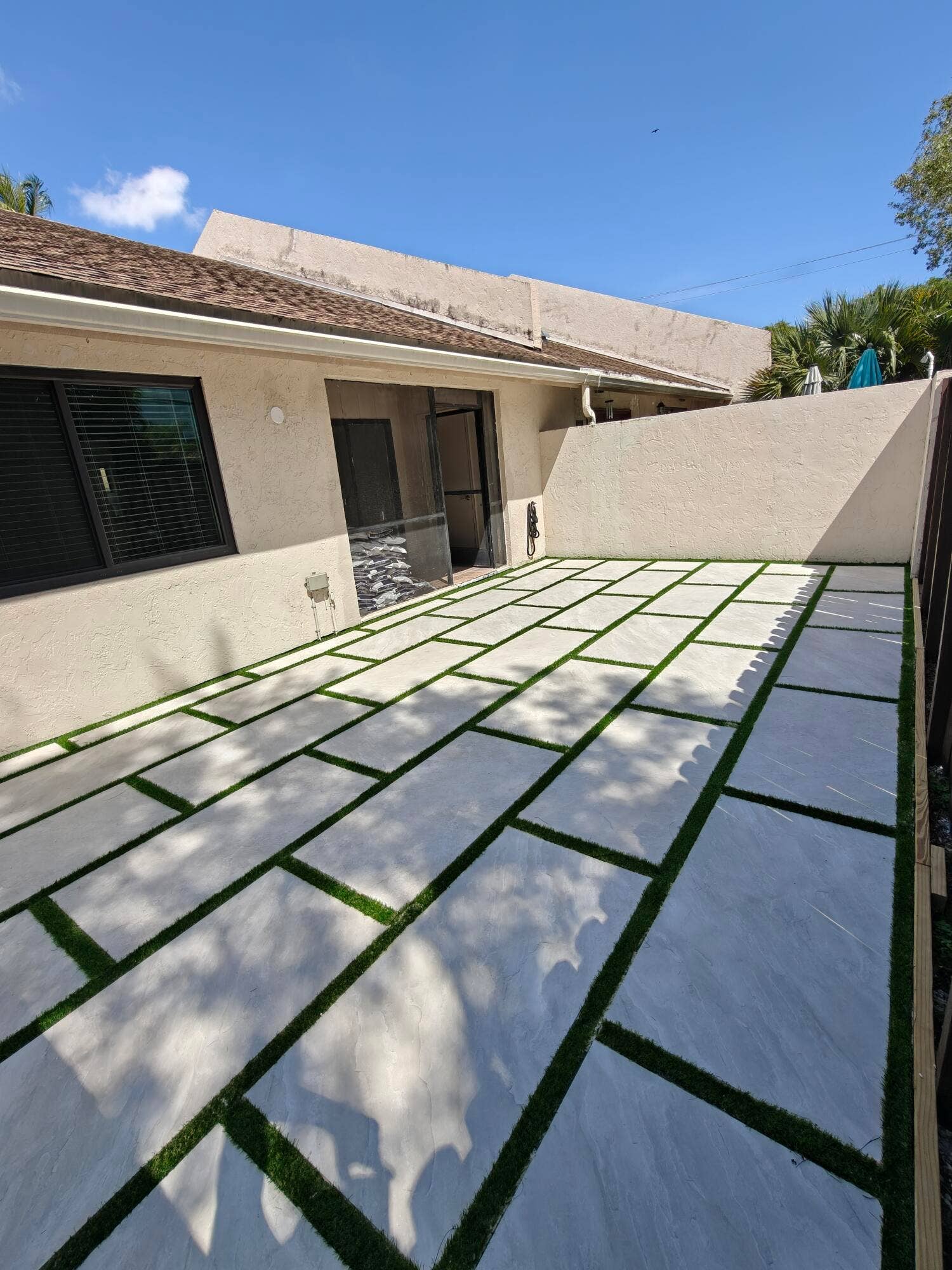 2700 S OAKLAND FOREST Drive, #603, Oakland Park, FL 33309 Outdoor patio featuring large-format concrete pavers with artificial turf inlay and a solid perimeter privacy wall