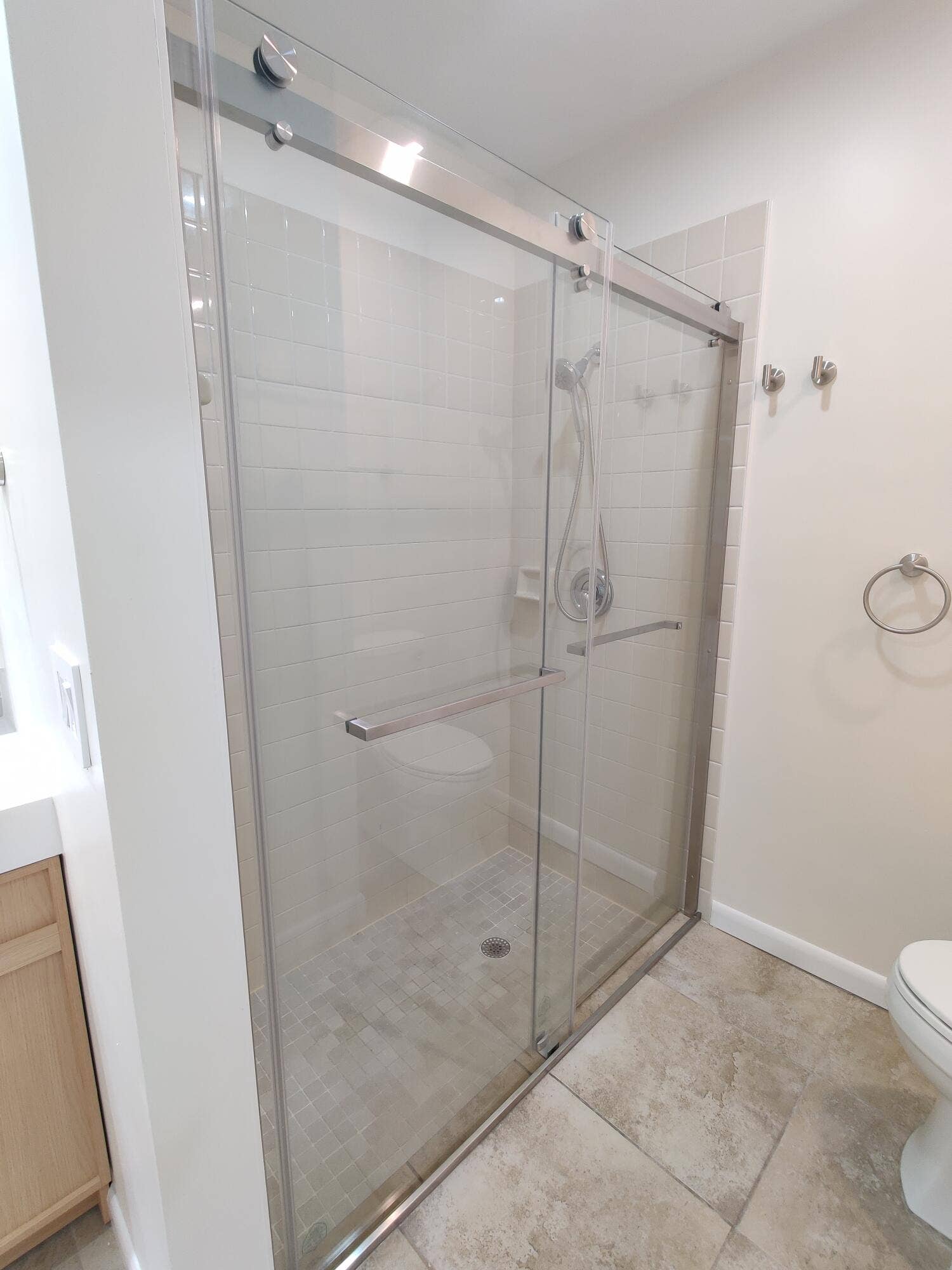 2700 S OAKLAND FOREST Drive, #603, Oakland Park, FL 33309 Walk-in shower featuring a frameless sliding glass door, brushed nickel hardware, handheld shower fixture, and subway tile surround