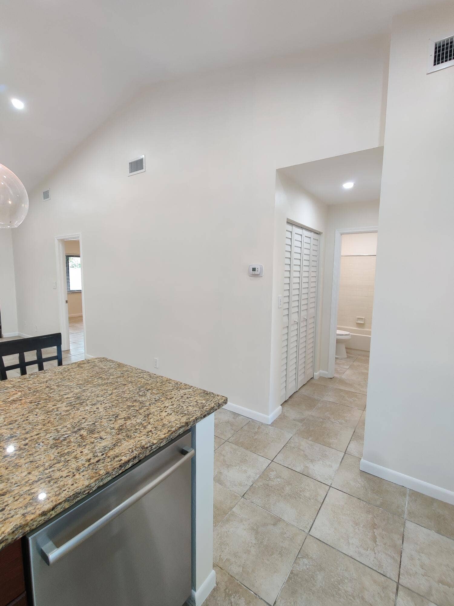 2700 S OAKLAND FOREST Drive, #603, Oakland Park, FL 33309 Vaulted ceiling, stone-finish countertops, stainless steel appliance, tile flooring, and louvered closet doors