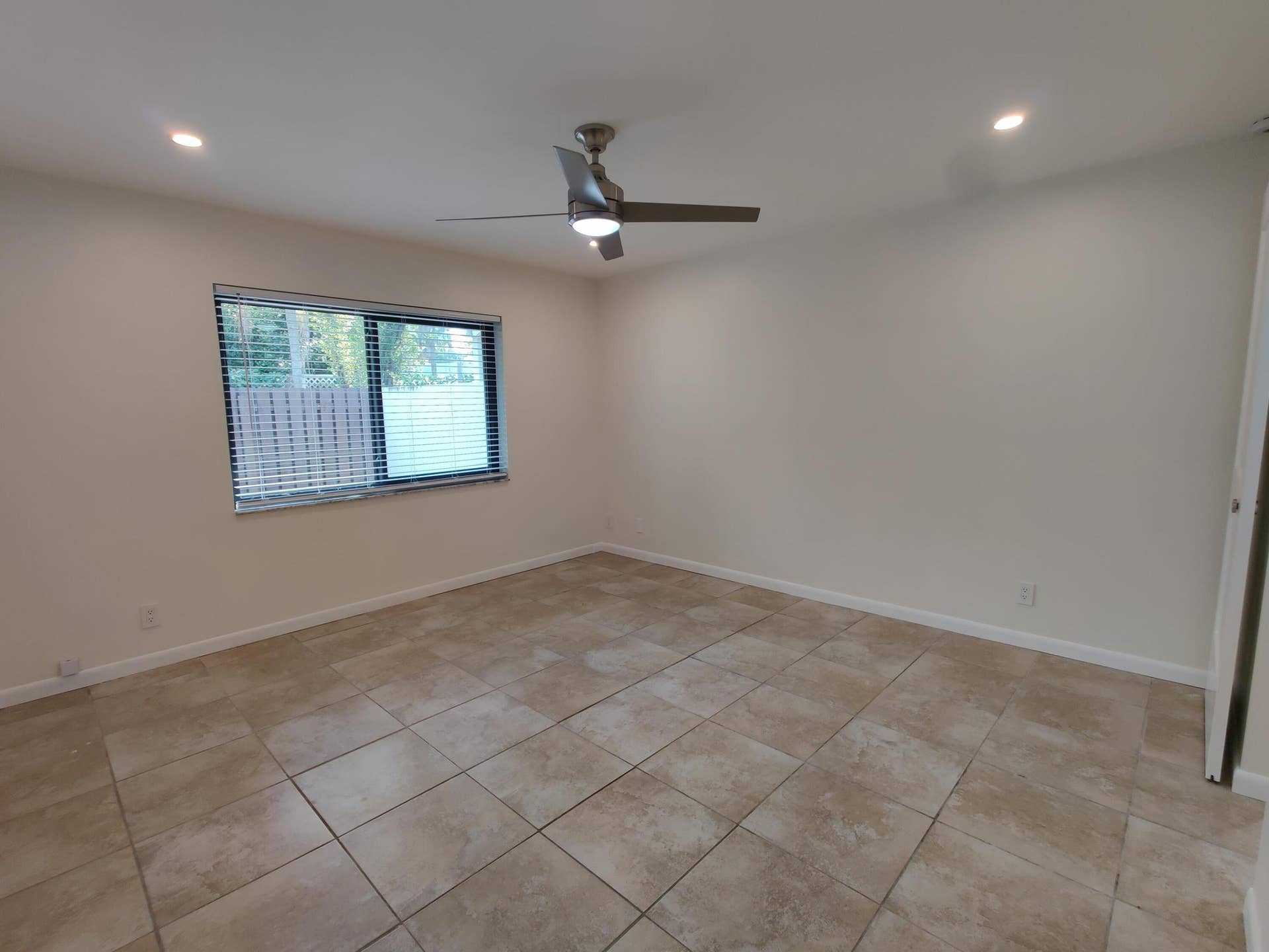 2700 S OAKLAND FOREST Drive, #603, Oakland Park, FL 33309 Neutral-toned room featuring large-format ceramic tile flooring, recessed lighting, and a brushed nickel ceiling fan with an integrated light fixture