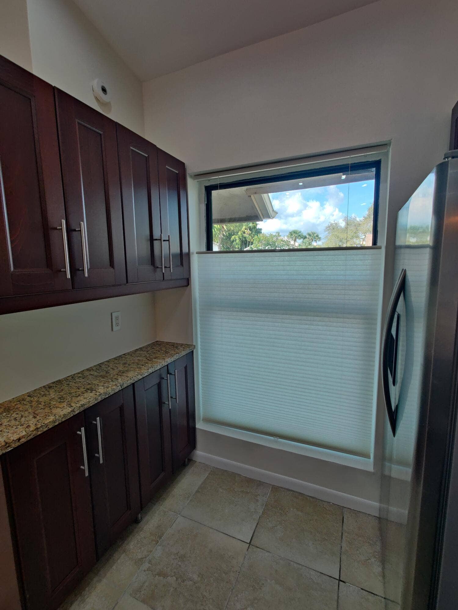 2700 S OAKLAND FOREST Drive, #603, Oakland Park, FL 33309 Rich-toned cabinetry featuring satin-finish hardware, stone-surface countertops, and tile flooring