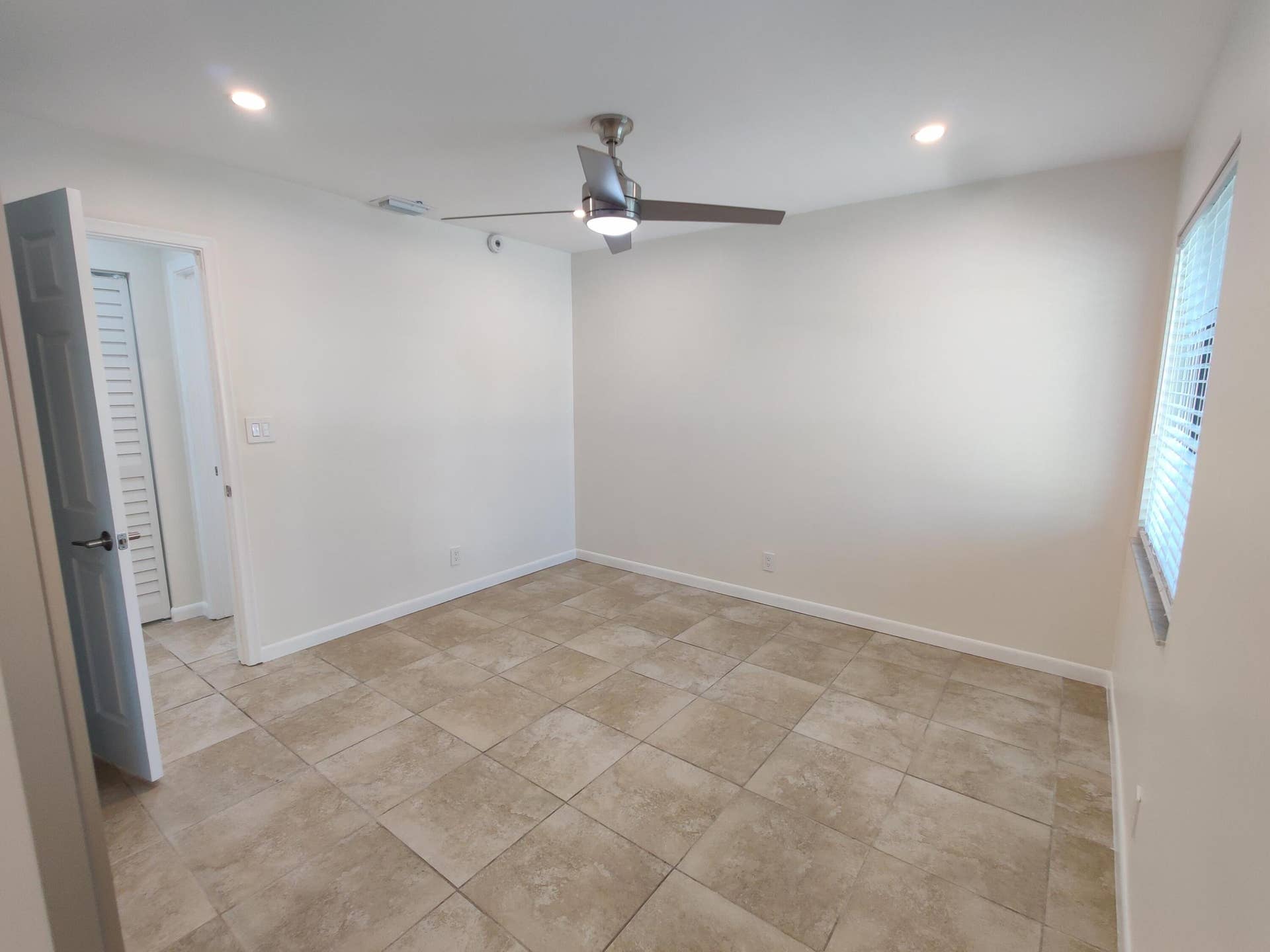 2700 S OAKLAND FOREST Drive, #603, Oakland Park, FL 33309 Neutral-toned tile flooring, brushed metal ceiling fan with integrated lighting, recessed ceiling lights, and louvered-style closet door
