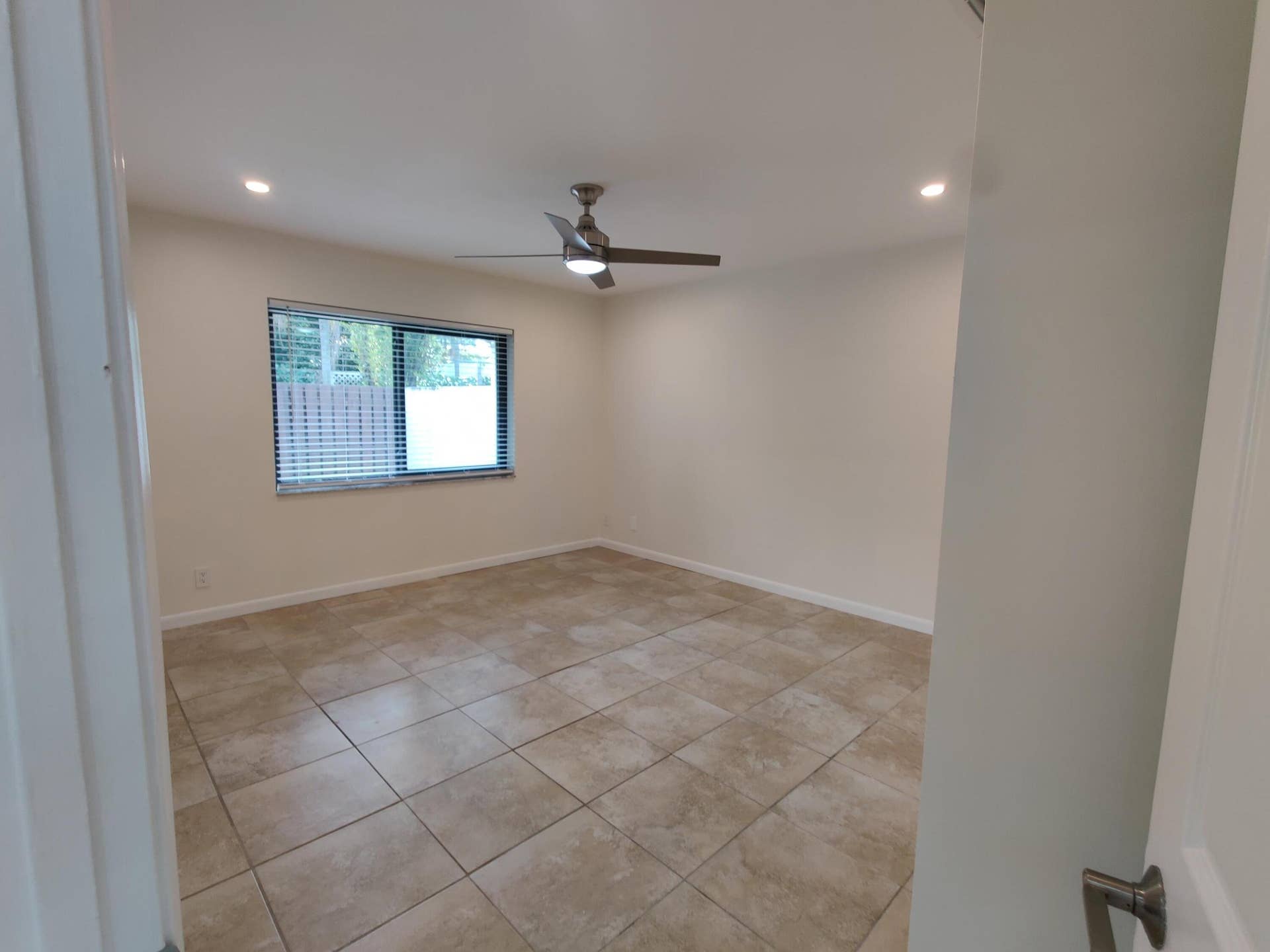 2700 S OAKLAND FOREST Drive, #603, Oakland Park, FL 33309 Neutral interior space featuring large-format stone-style tile flooring, recessed ceiling lighting, and a brushed-nickel ceiling fan
