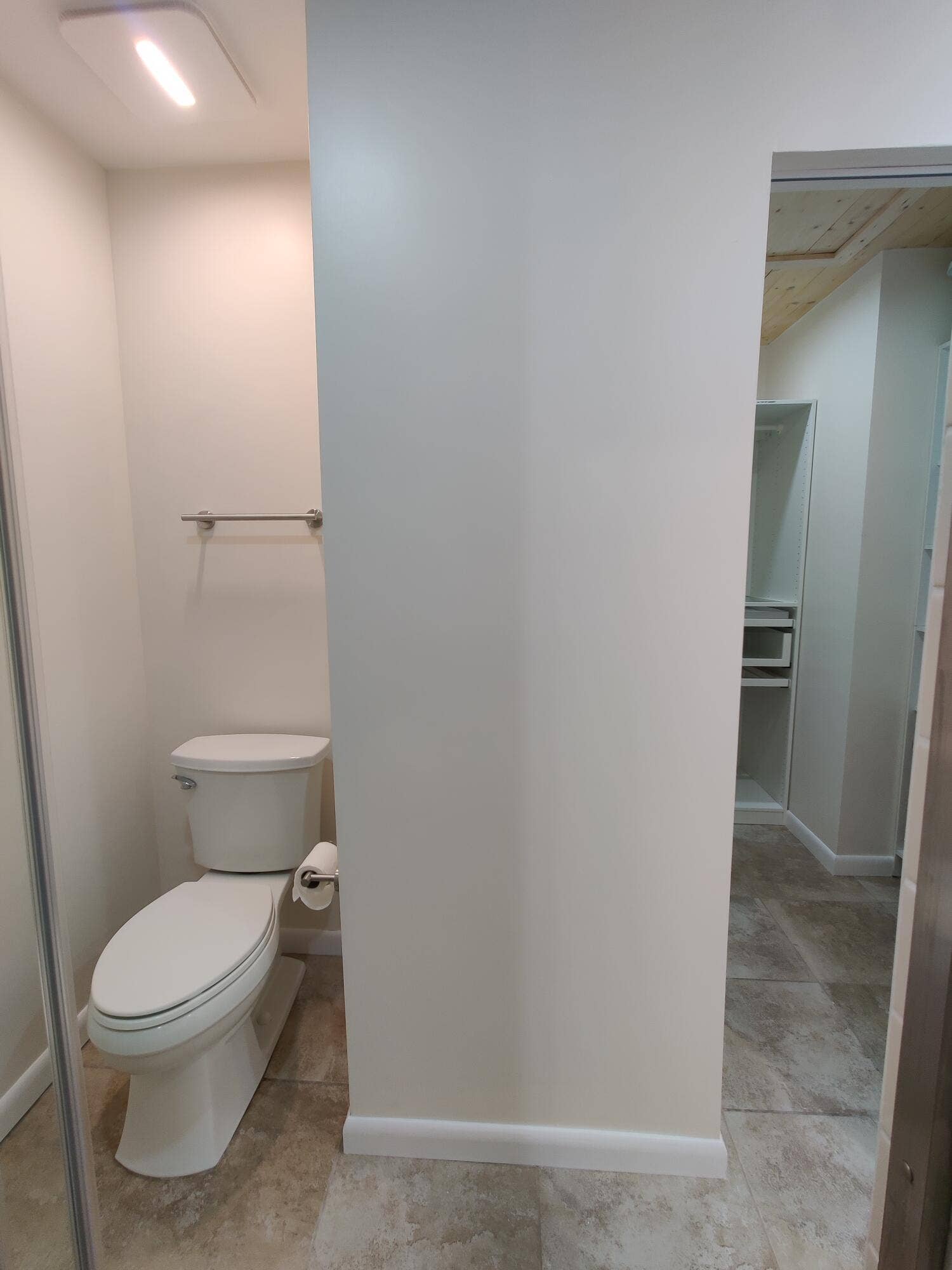 2700 S OAKLAND FOREST Drive, #603, Oakland Park, FL 33309 Ceramic tile flooring, white porcelain toilet, wall-mounted metal towel bar, and built-in closet storage featuring shelving and a hanging rod