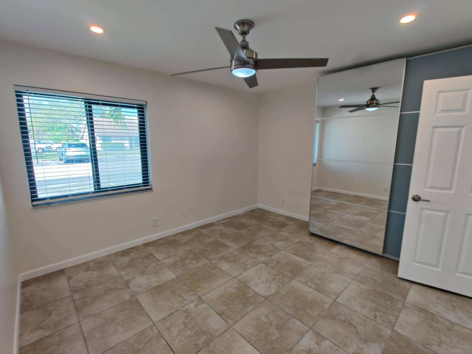 2700 S OAKLAND FOREST Drive, #603, Oakland Park, FL 33309 Interior room featuring tile flooring, a mirrored closet, recessed ceiling lighting, and a metal-finish ceiling fan
