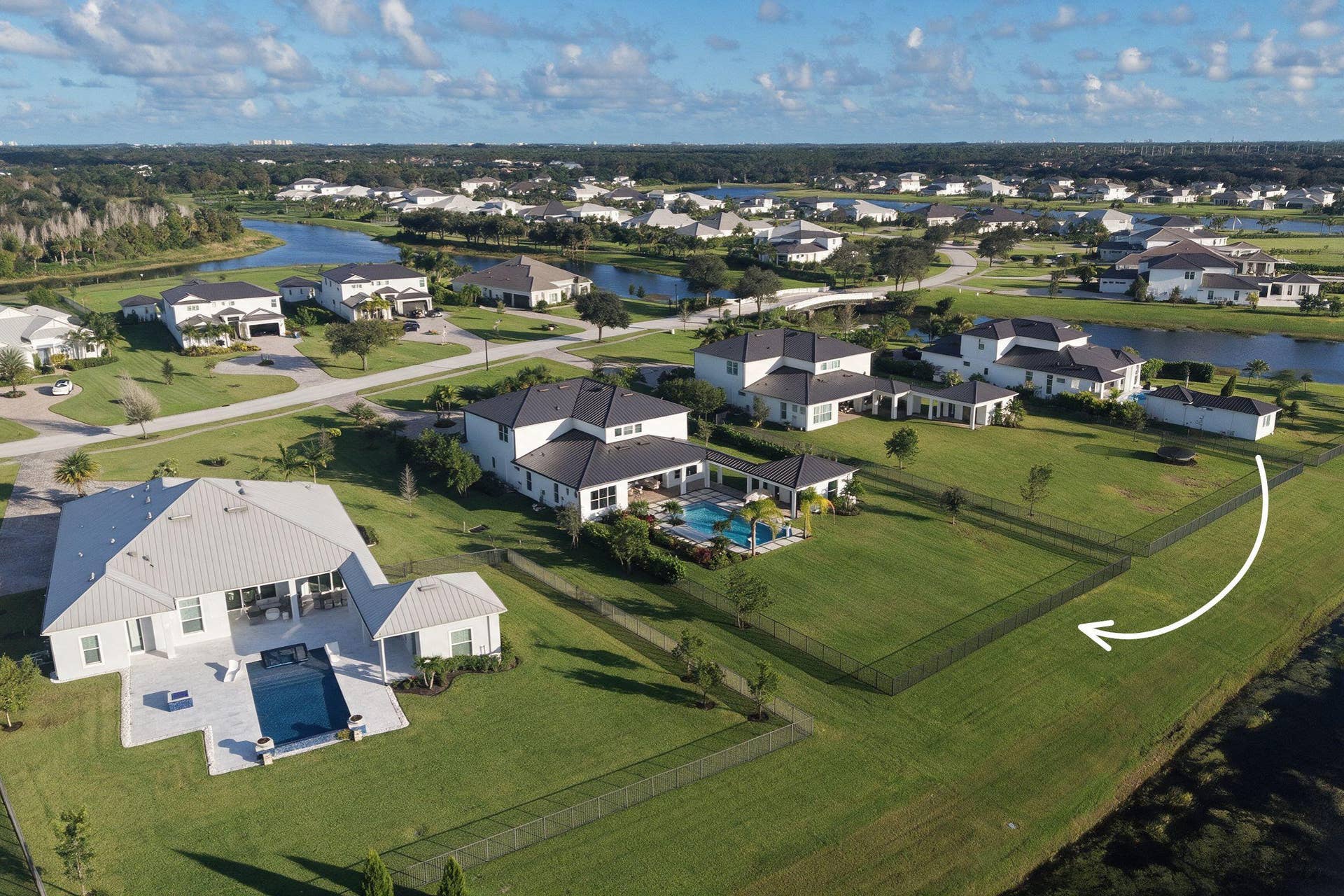 20036 SE BRIDGEWATER Drive, Jupiter, FL 33458 Expansive rear yard featuring manicured lawn, perimeter aluminum fencing, and structural swimming pool
