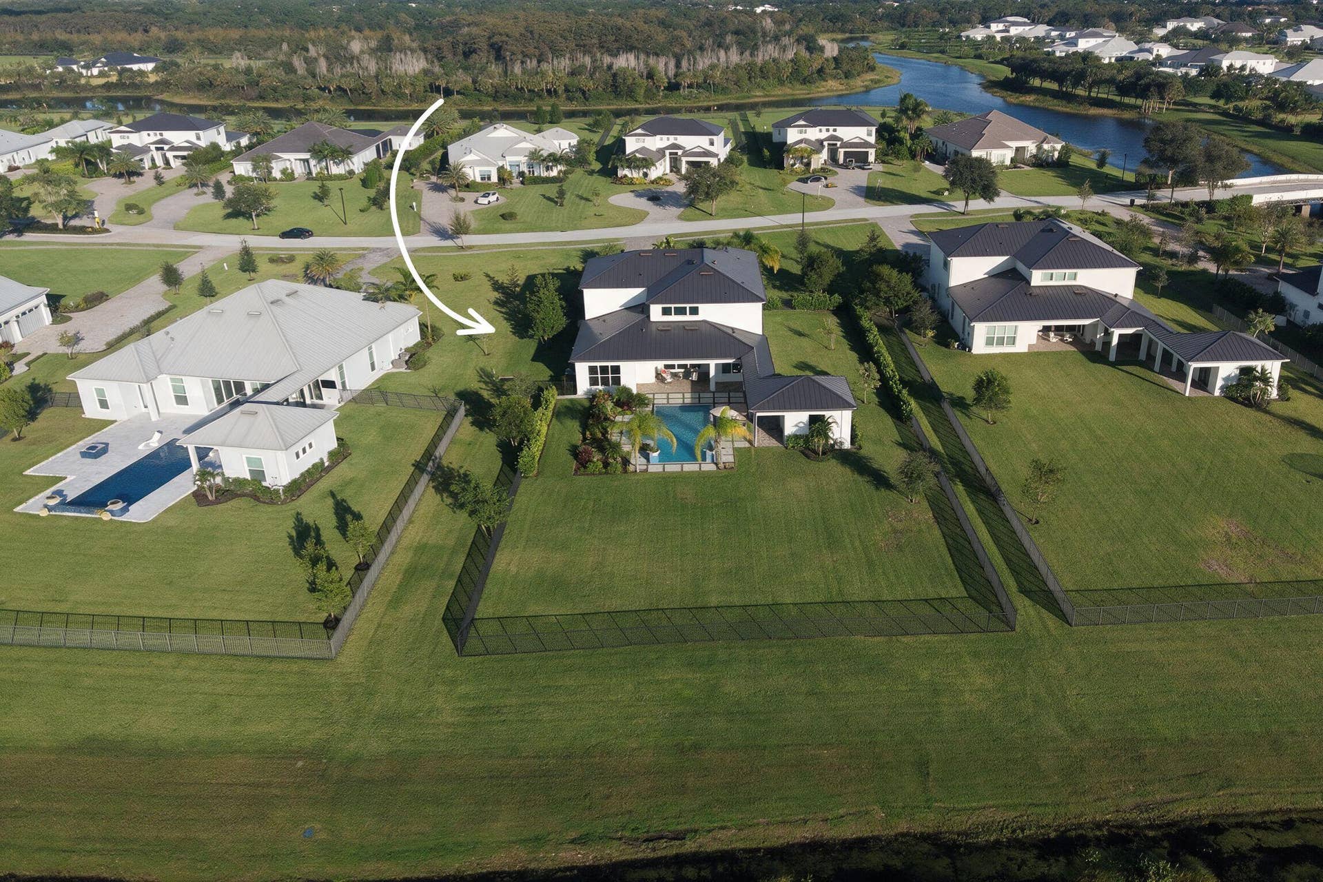 20036 SE BRIDGEWATER Drive, Jupiter, FL 33458 Aerial perspective of property featuring an expansive fenced backyard, private swimming pool, covered lanai, and multi-level roofline