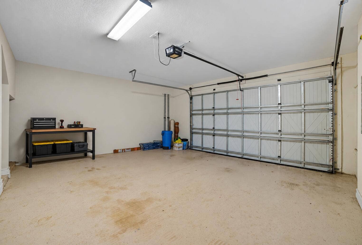 13011 Riverwalk Circle N, Plantation, Plantation, FL 33325 Two-car garage featuring a sectional overhead door, automated garage door opener, overhead lighting, and painted concrete flooring