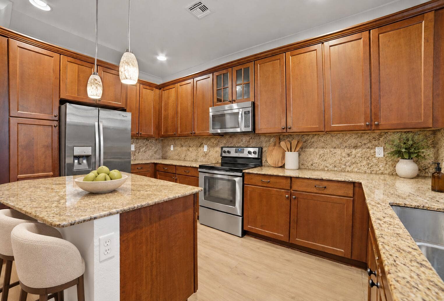 13011 Riverwalk Circle N, Plantation, Plantation, FL 33325 Kitchen featuring medium-toned wood cabinetry, stone countertops, stainless steel appliances, a central island, and glass pendant lighting