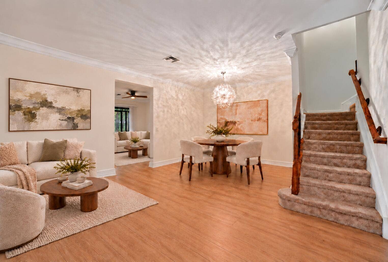 13011 Riverwalk Circle N, Plantation, Plantation, FL 33325 Open-concept area featuring wood-finish flooring, crown molding, a spherical pendant light fixture, and a staircase with a natural wood handrail