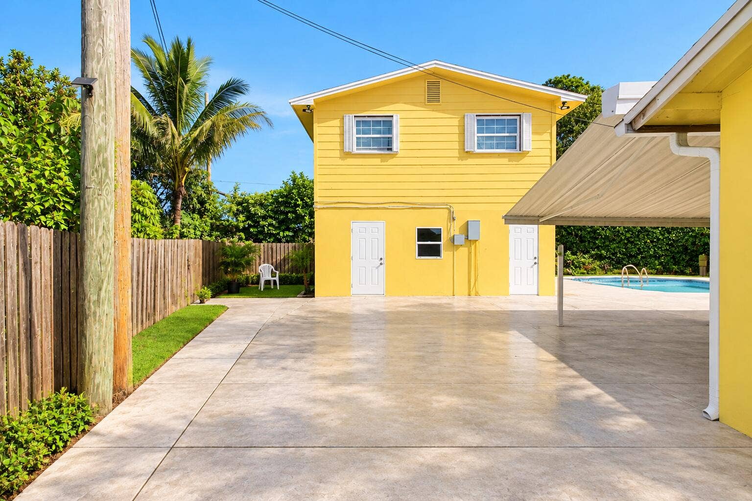 Sunny Yellow House with Tropical Yard