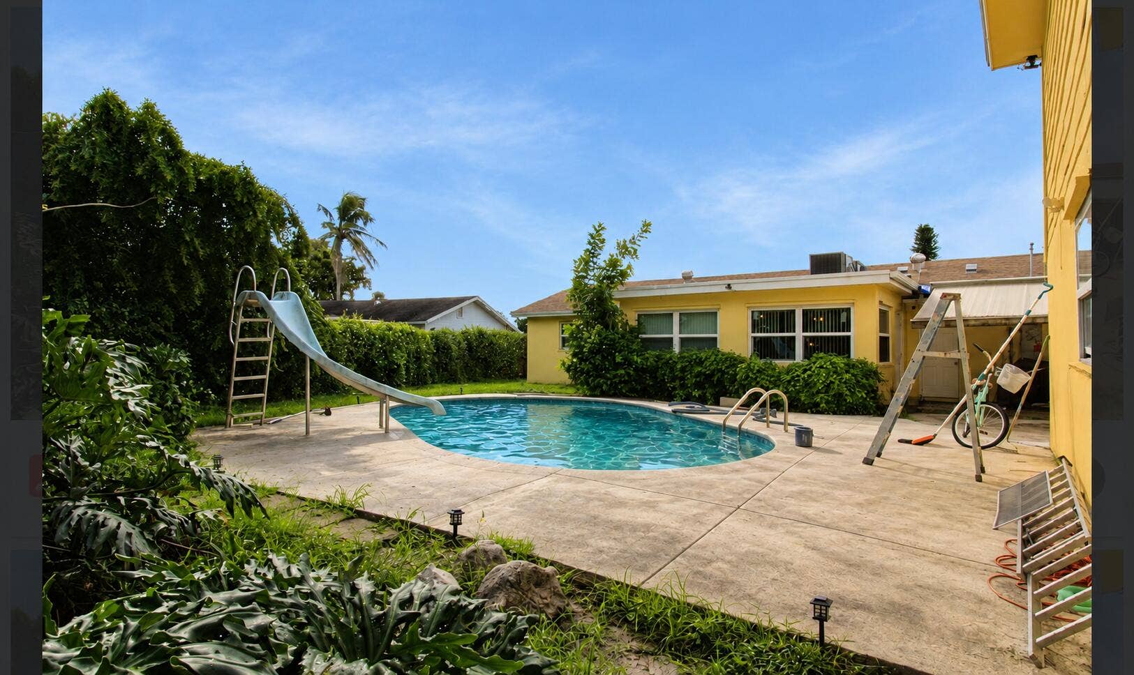 Natural-looking backyard pool and concre