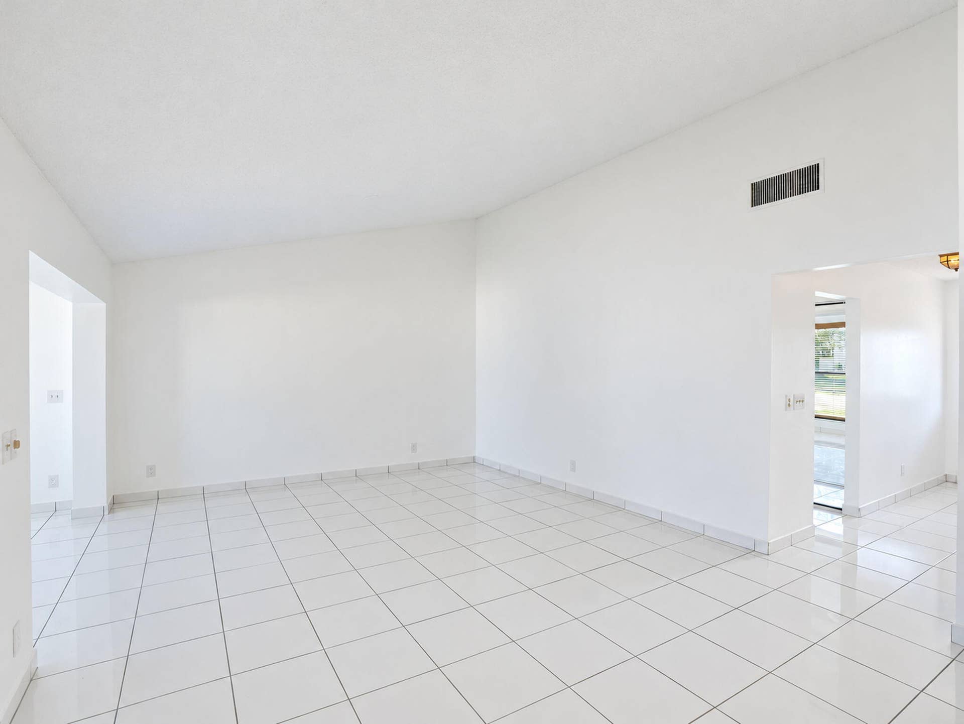 2079 SW 16TH Circle, Deerfield Beach, FL 33442 Open floor plan featuring vaulted ceilings and polished ceramic tile flooring