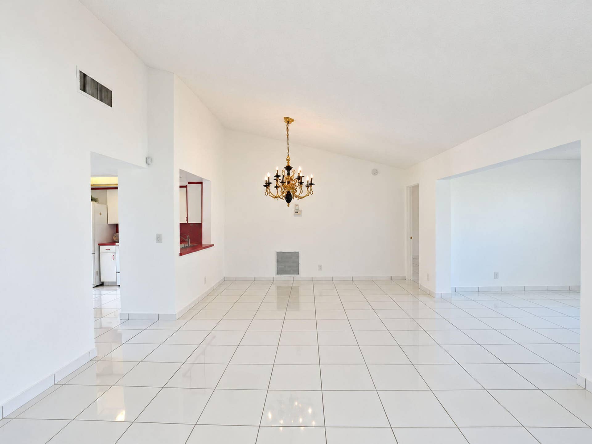 2079 SW 16TH Circle, Deerfield Beach, FL 33442 Vaulted ceilings, polished white tile flooring, and a decorative multi-arm chandelier