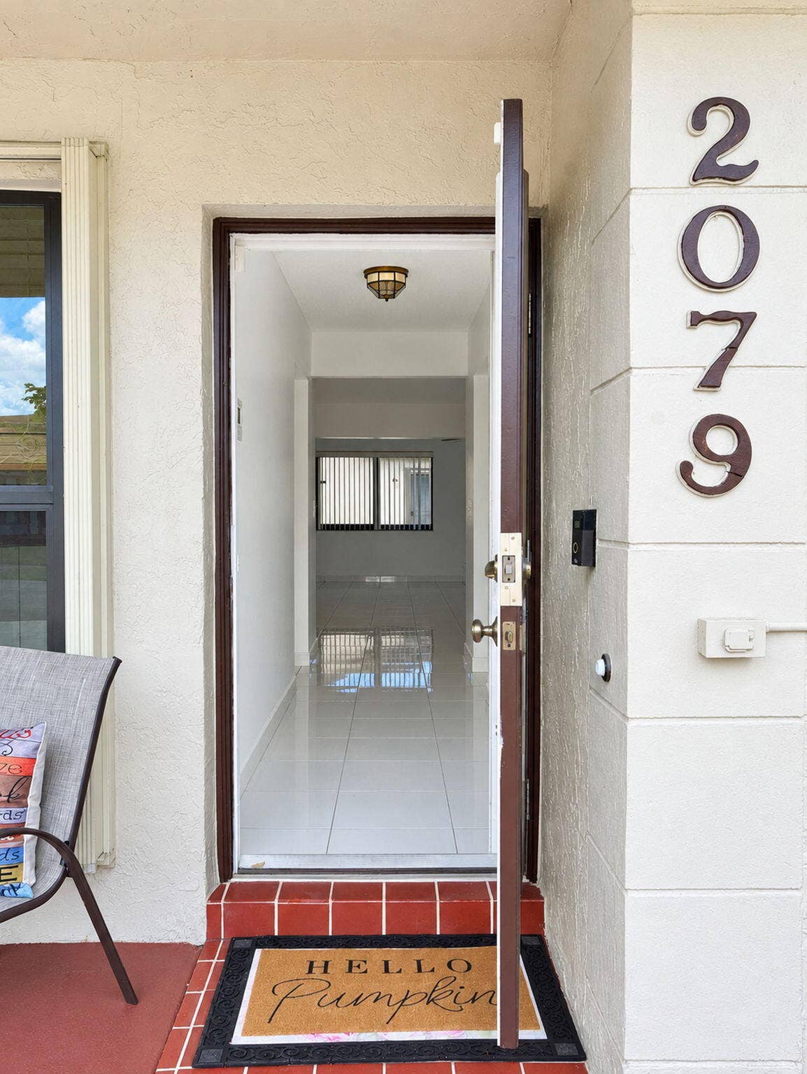 2079 SW 16TH Circle, Deerfield Beach, FL 33442 Entryway featuring a single-panel door, ceramic tile flooring, a flush-mount ceiling light fixture, and exterior address numerals