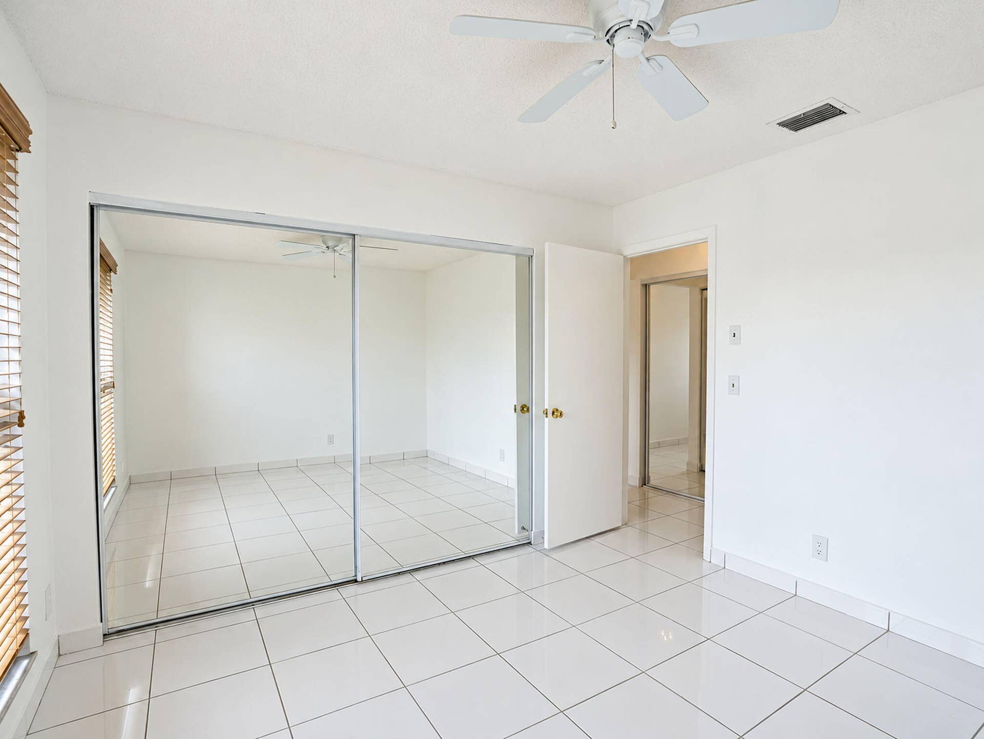2079 SW 16TH Circle, Deerfield Beach, FL 33442 Tile flooring, sliding mirrored closet doors, ceiling fan, and window blinds
