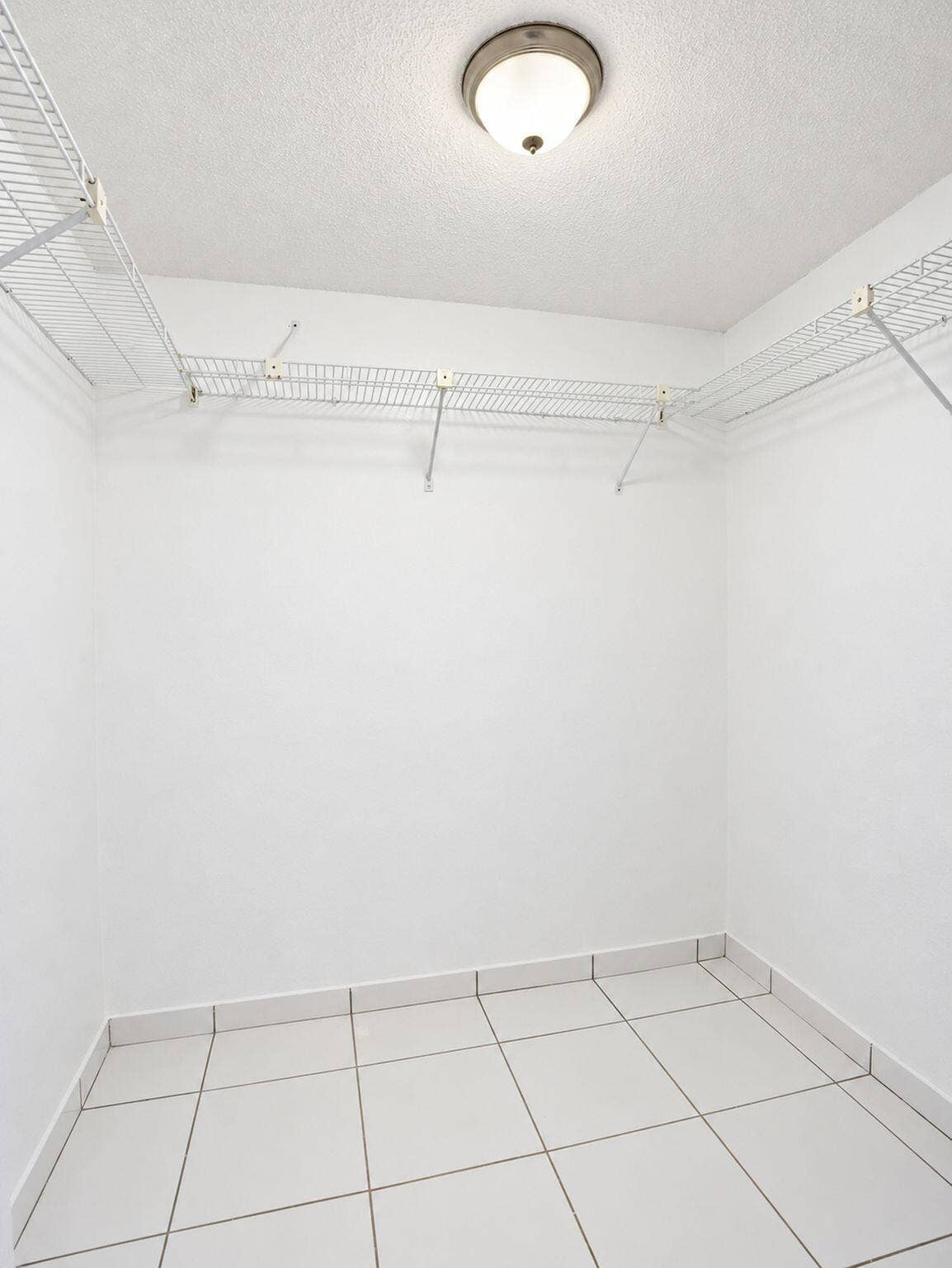 2079 SW 16TH Circle, Deerfield Beach, FL 33442 Storage area featuring white tile flooring, ceiling-mounted light fixture, and perimeter wire shelving