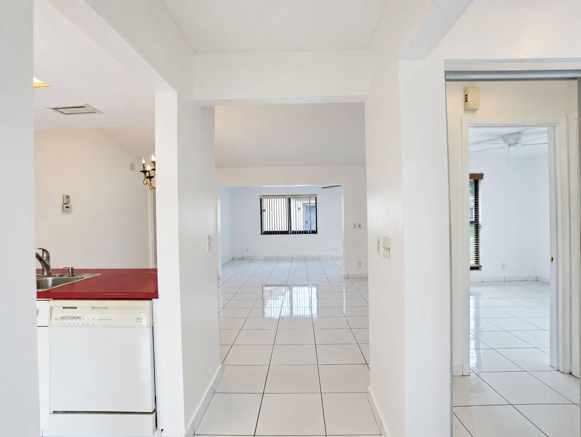 2079 SW 16TH Circle, Deerfield Beach, FL 33442 Interior featuring white ceramic floor tiling throughout, solid-surface countertops, and a built-in dishwasher