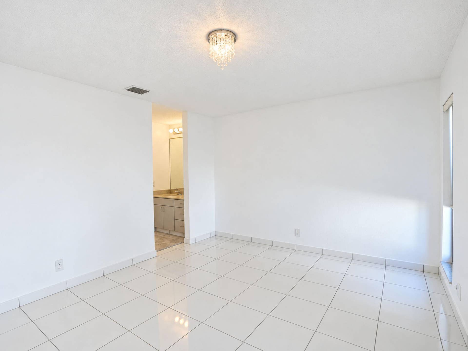 2079 SW 16TH Circle, Deerfield Beach, FL 33442 Interior space featuring white tile flooring, neutral walls, and a crystal flush-mount light fixture