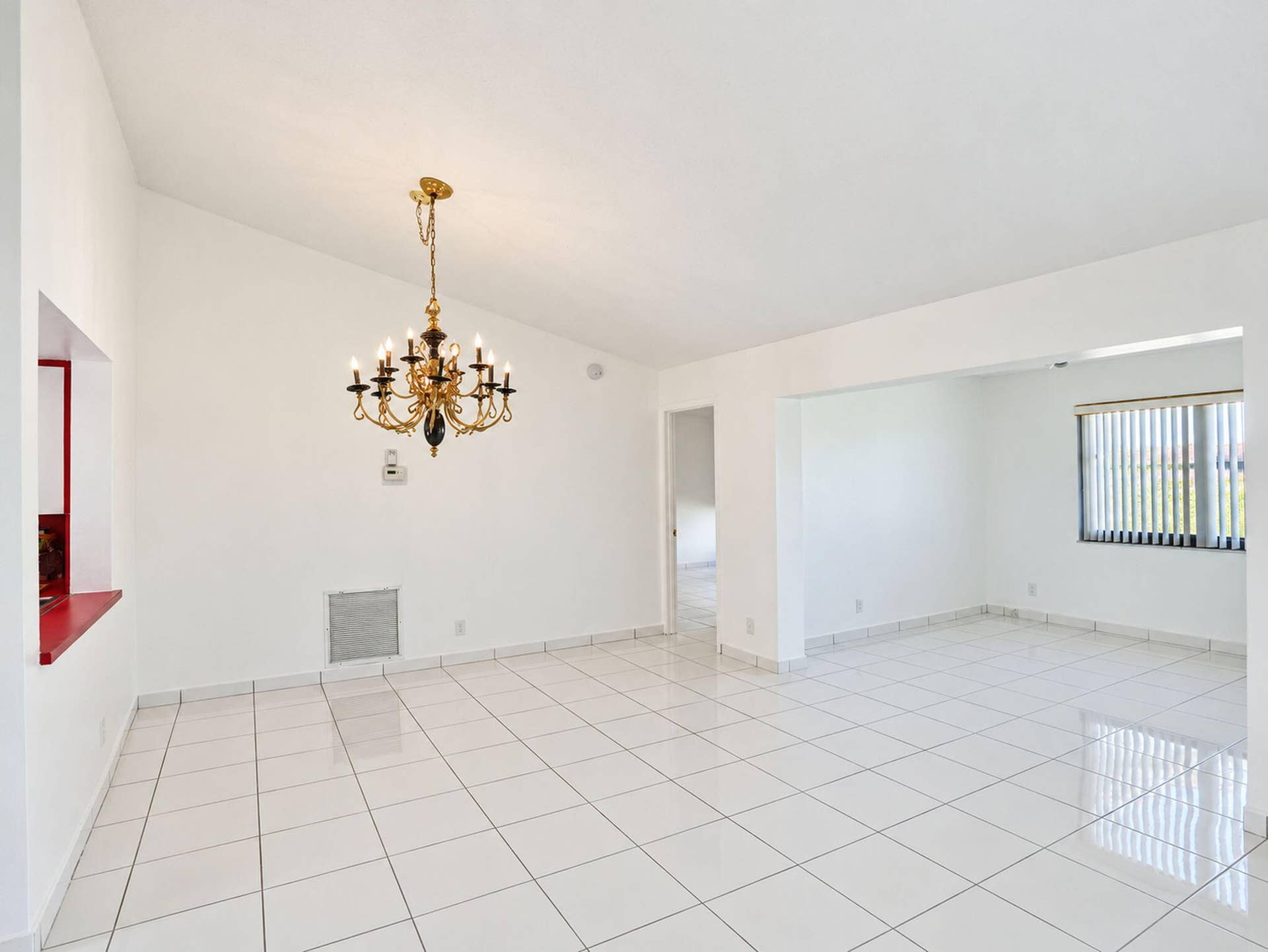 2079 SW 16TH Circle, Deerfield Beach, FL 33442 Interior featuring high vaulted ceilings, polished ceramic tile flooring, a multi-arm brass chandelier, and vertical blinds