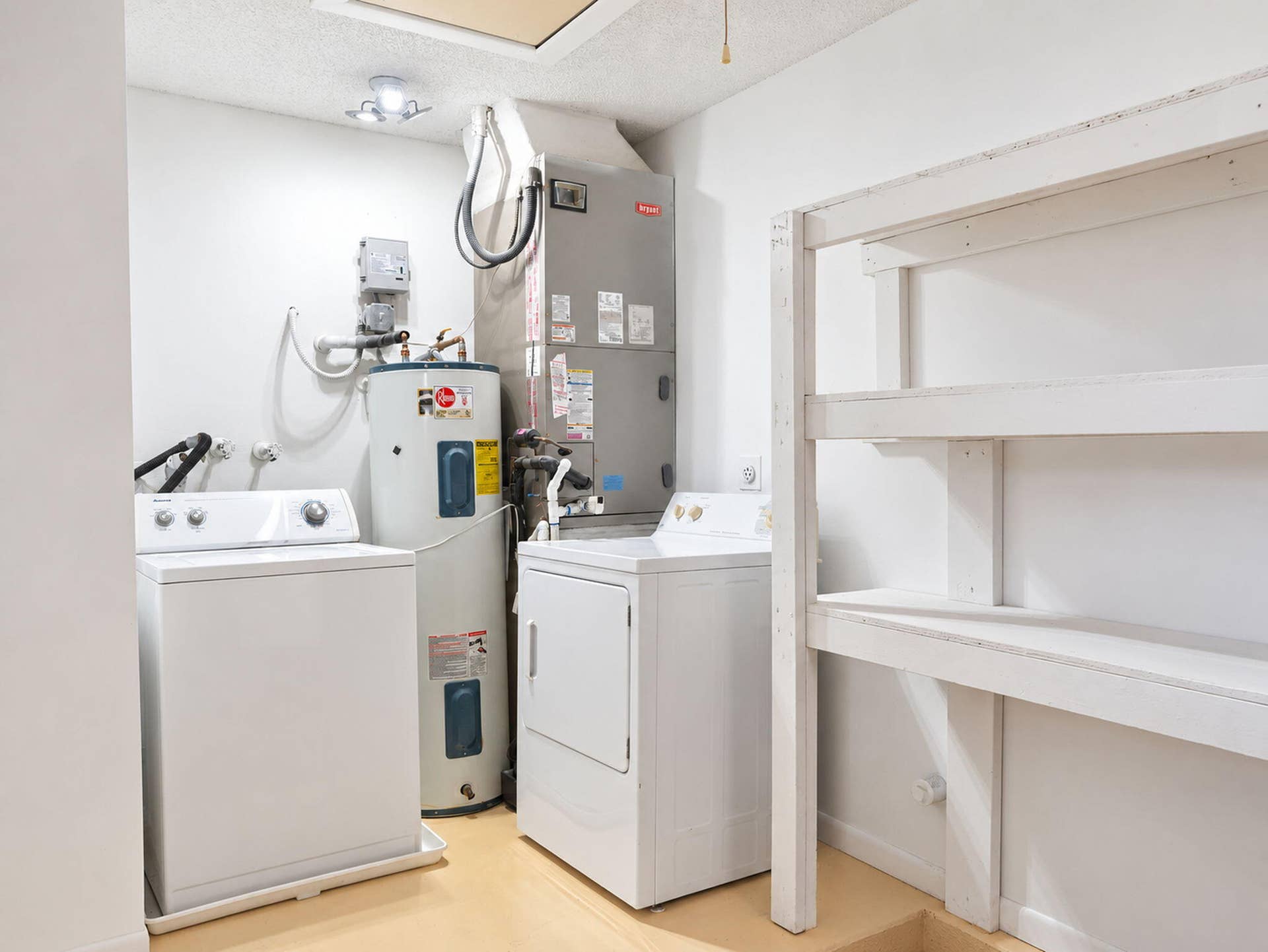 2079 SW 16TH Circle, Deerfield Beach, FL 33442 Utility area featuring a water heater, HVAC unit, washer and dryer connections, and built-in shelving