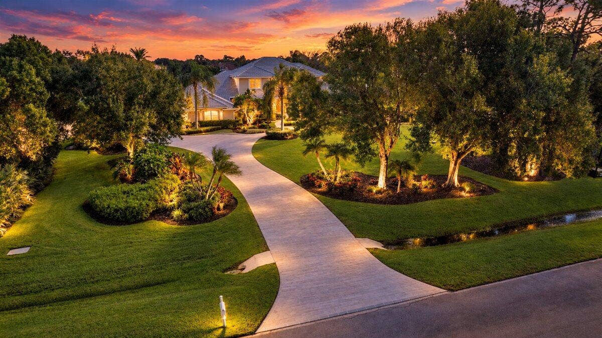 7953 Saddlebrook Drive, Port St Lucie, FL 34986 190-Twilight Driveway with Warm Landscap