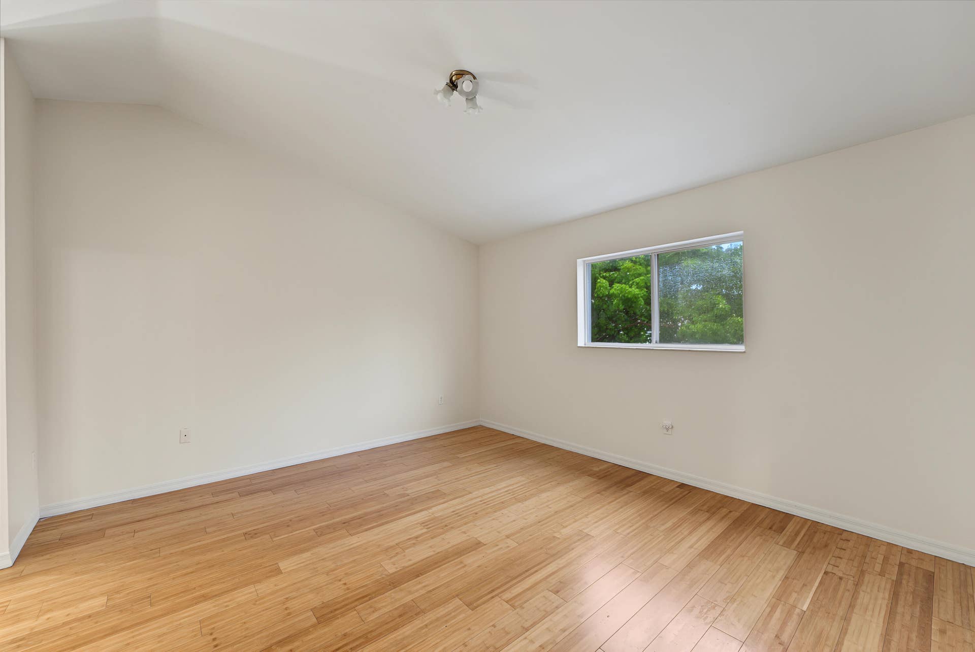 21109 NE 3RD Court, Miami, FL 33179 Vaulted ceiling featuring wood-finish flooring and a single-pane window