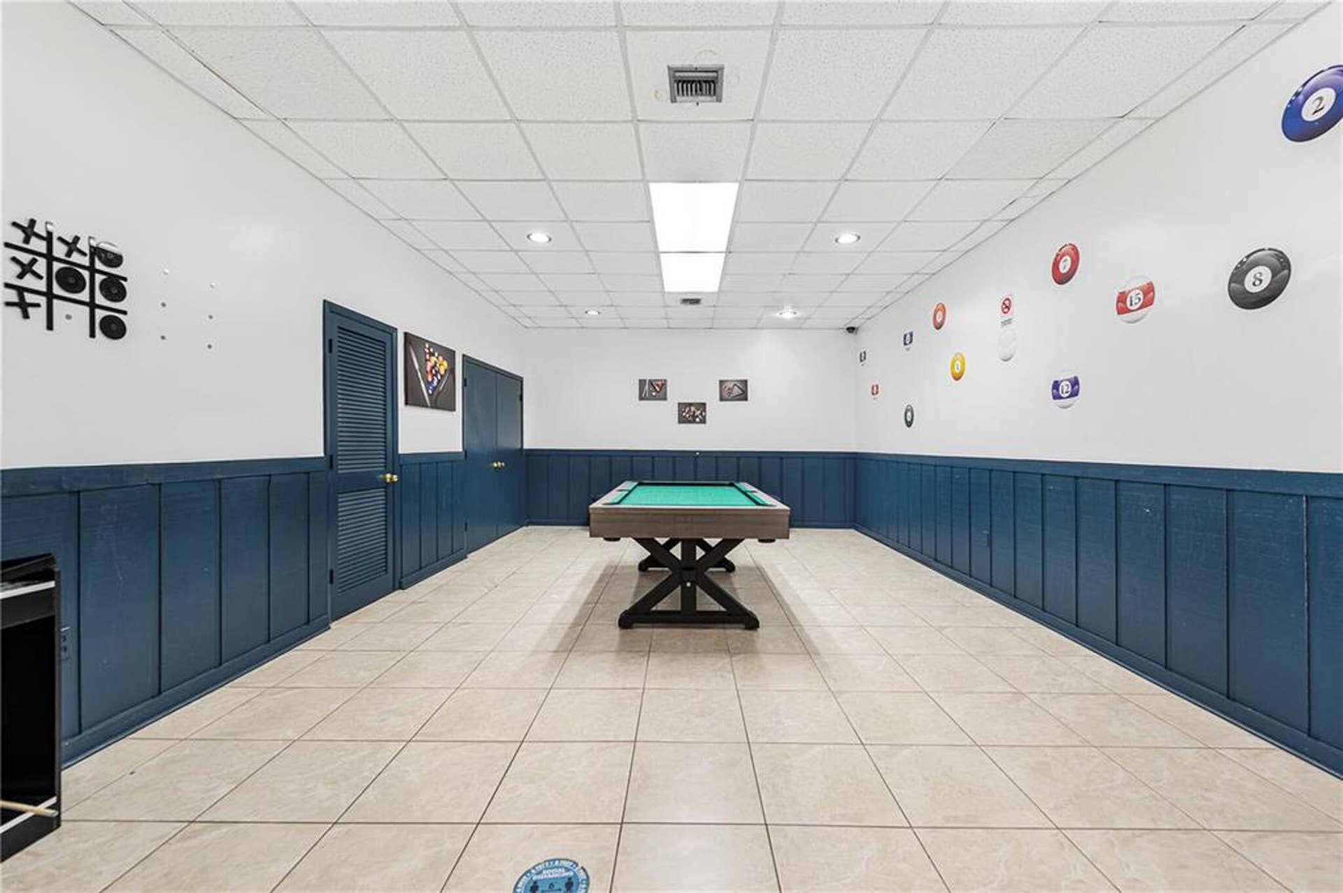 21109 NE 3RD Court, Miami, FL 33179 Room featuring ceramic tile flooring, blue board-and-batten wainscoting, and a drop ceiling with recessed lighting