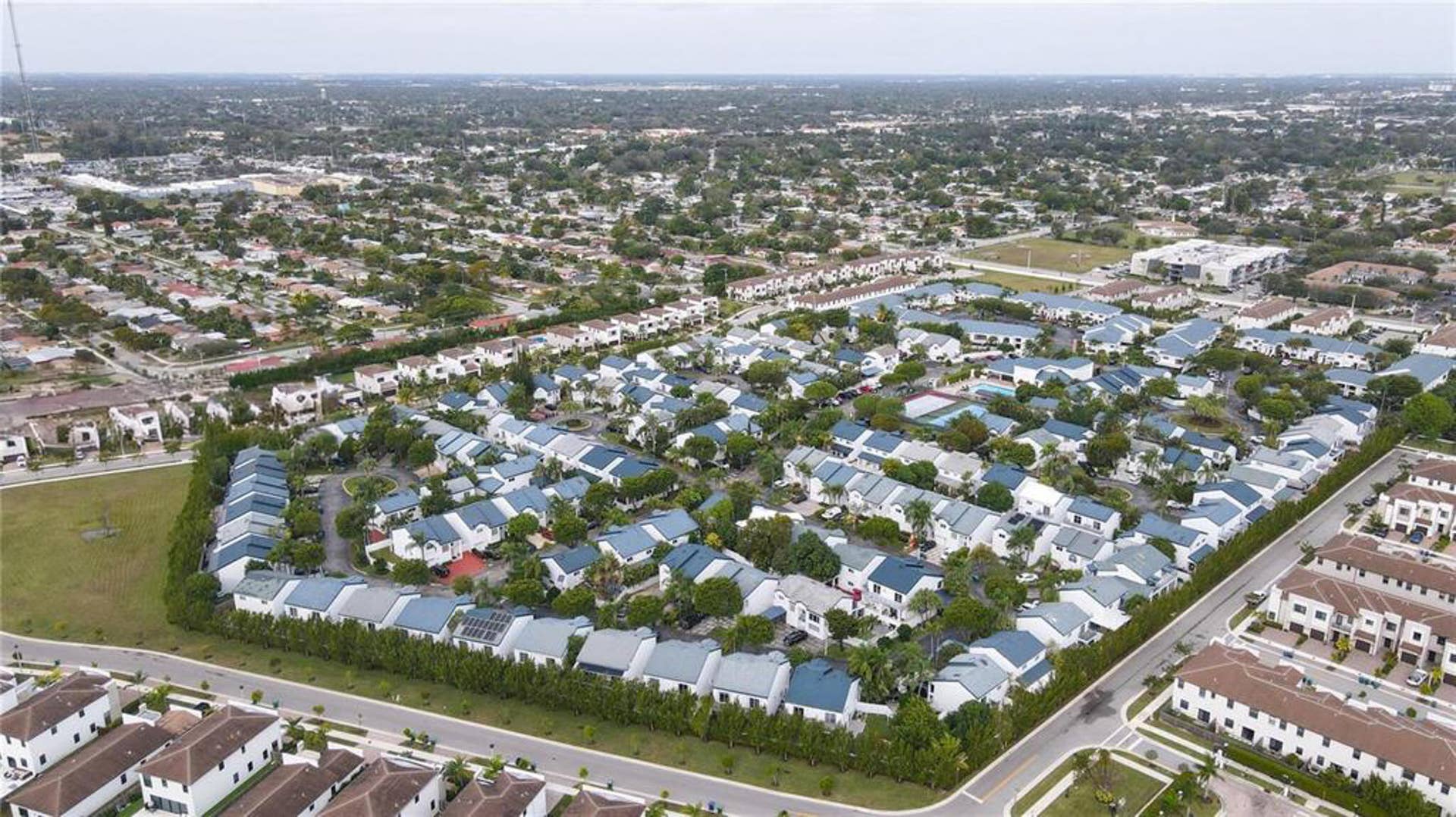 21109 NE 3RD Court, Miami, FL 33179 Aerial perspective of a planned community featuring multi-unit residential structures, uniform rooflines, paved access roads, and established mature landscaping