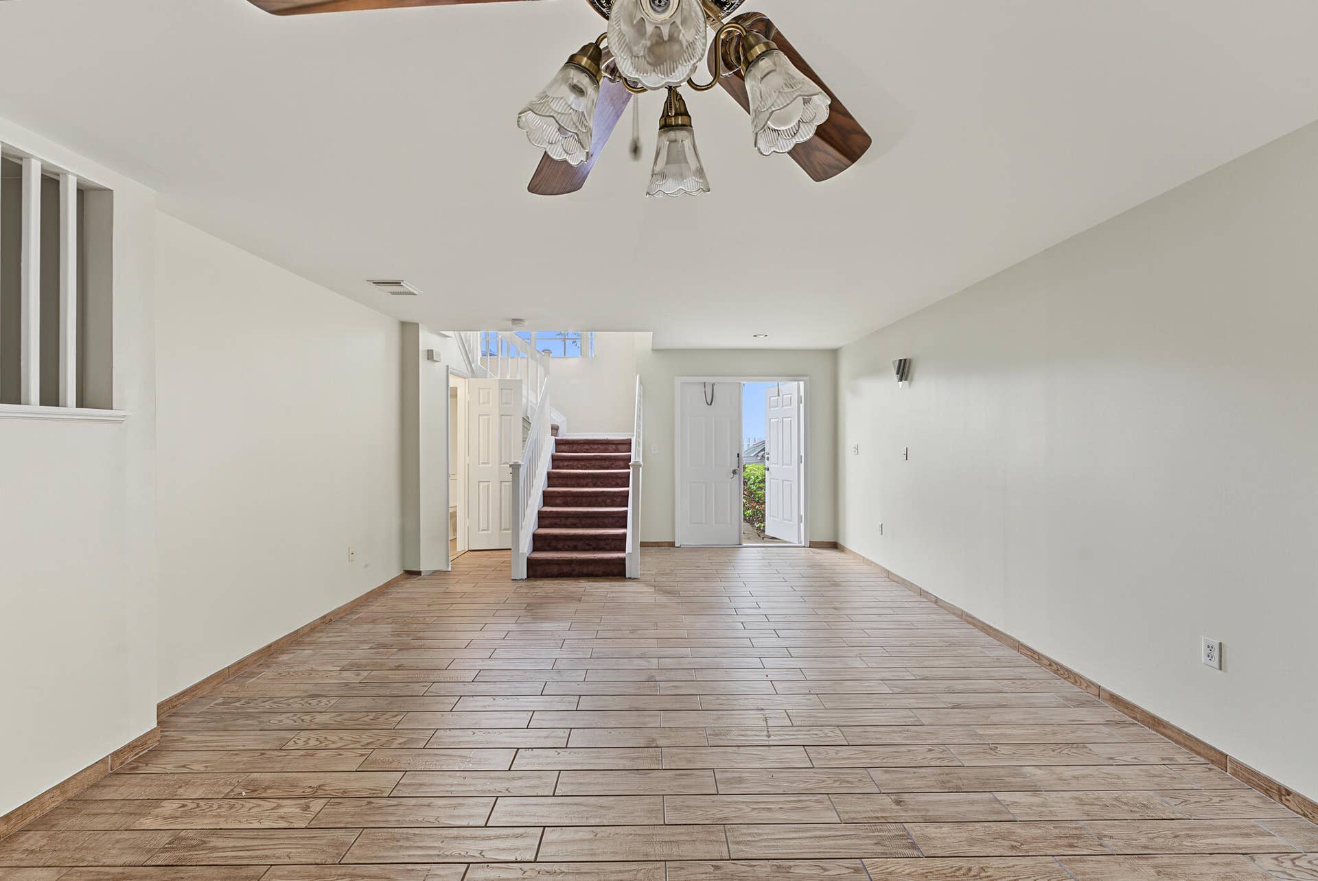 21109 NE 3RD Court, Miami, FL 33179 Interior space featuring wood-finish tile flooring, a multi-bulb ceiling fan, and a staircase with carpeted treads