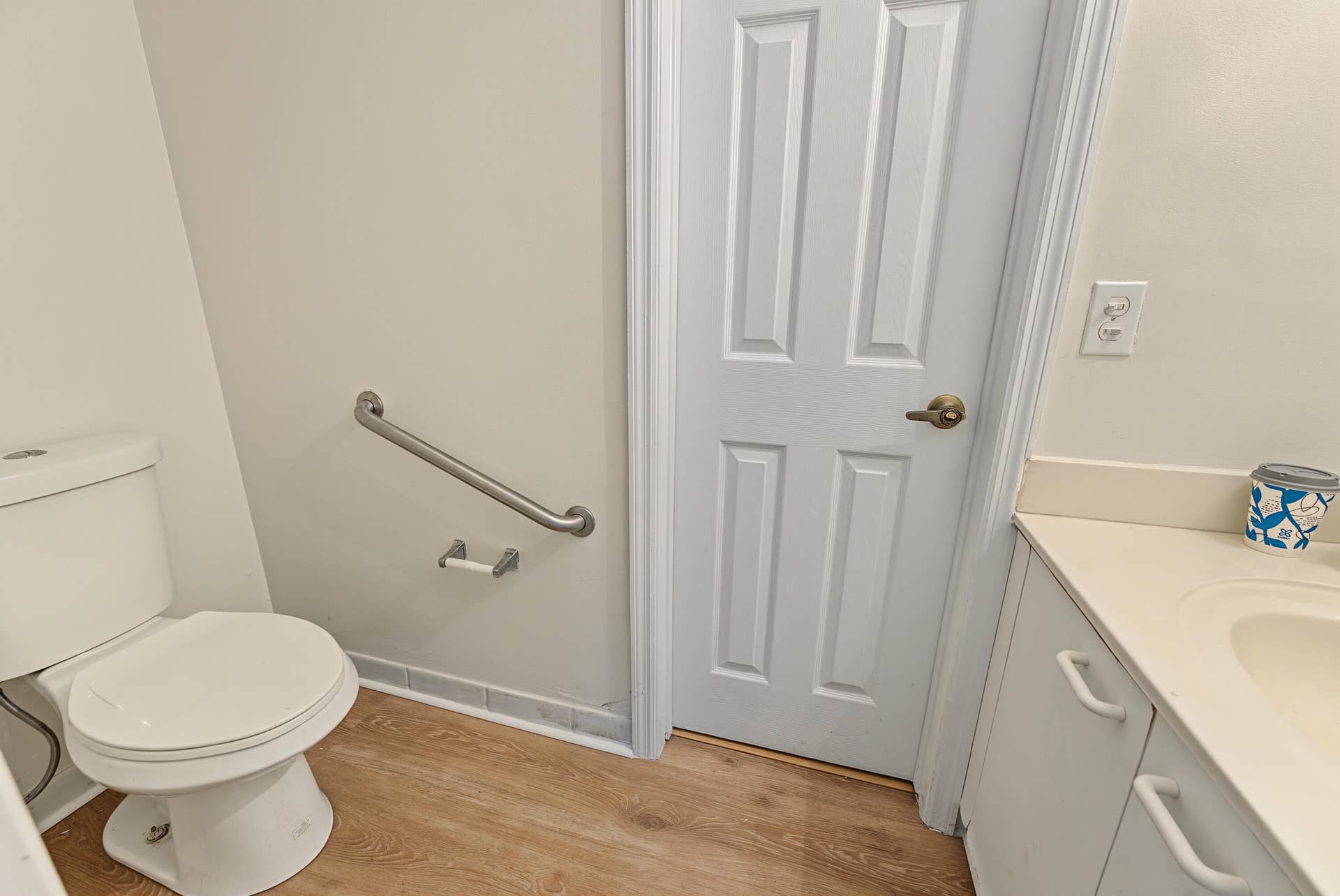 21109 NE 3RD Court, Miami, FL 33179 Bathroom featuring wood-finish flooring, a vanity with a solid-surface countertop, an integrated sink, and a wall-mounted stainless steel support rail
