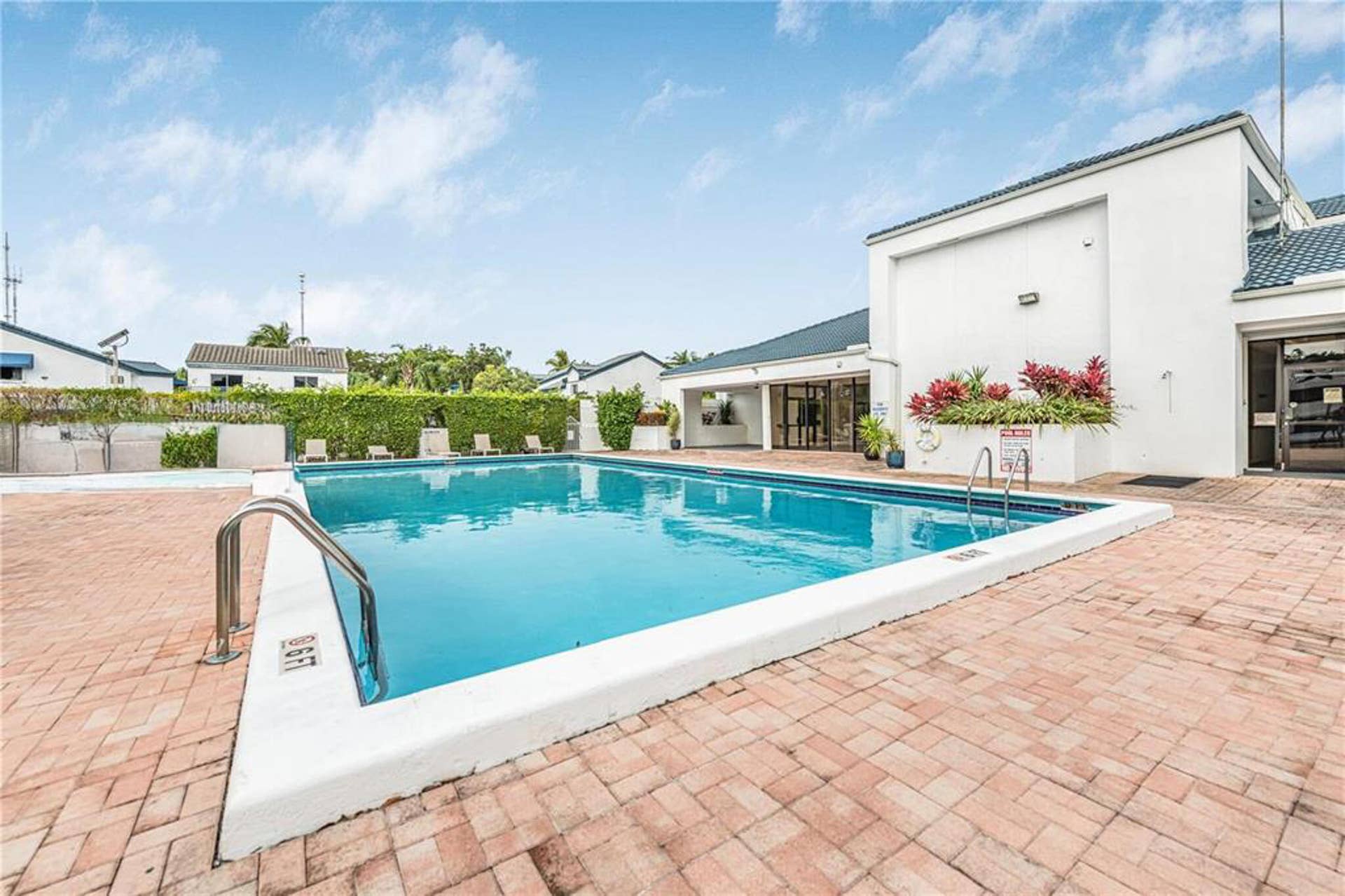 21109 NE 3RD Court, Miami, FL 33179 Swimming pool featuring brick paver decking, metal entry rails, and integrated landscape planters