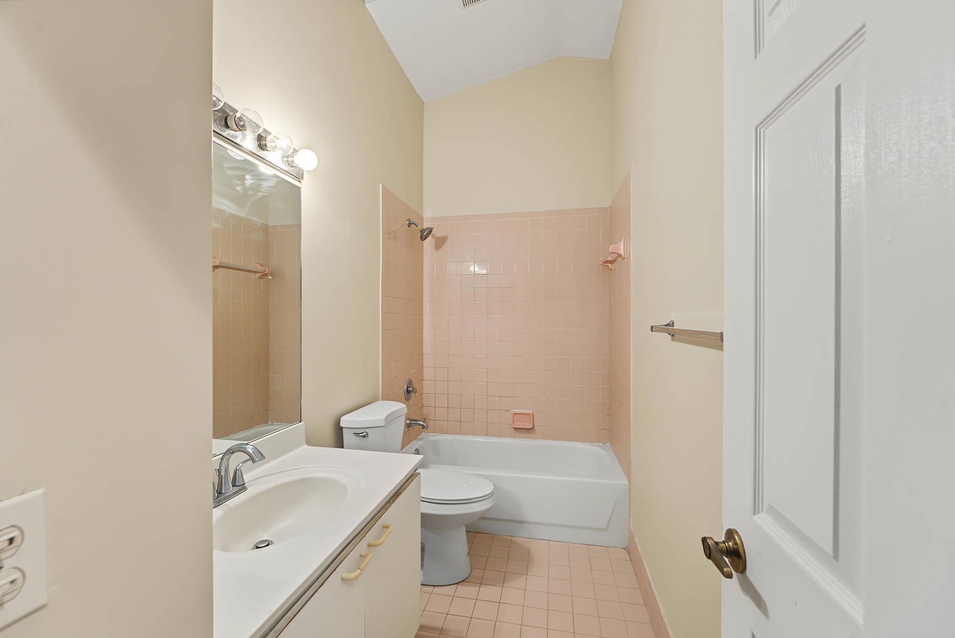 21109 NE 3RD Court, Miami, FL 33179 Bathroom featuring a vaulted ceiling, vanity with a white integrated sink, porcelain-tiled tub enclosure, and ceramic-tiled flooring