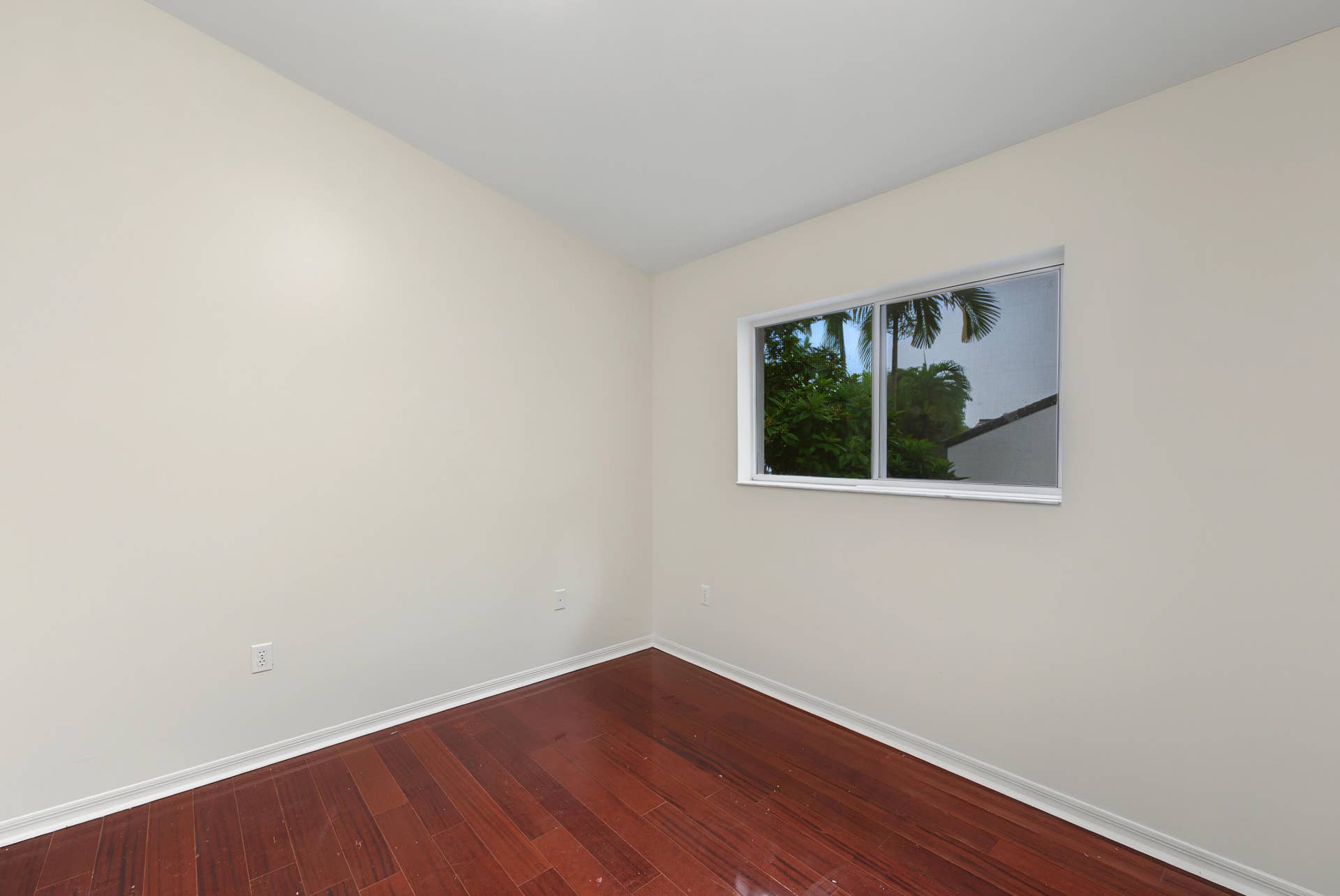 21109 NE 3RD Court, Miami, FL 33179 Neutral-toned interior space featuring wood-finish flooring and a single horizontal sliding window