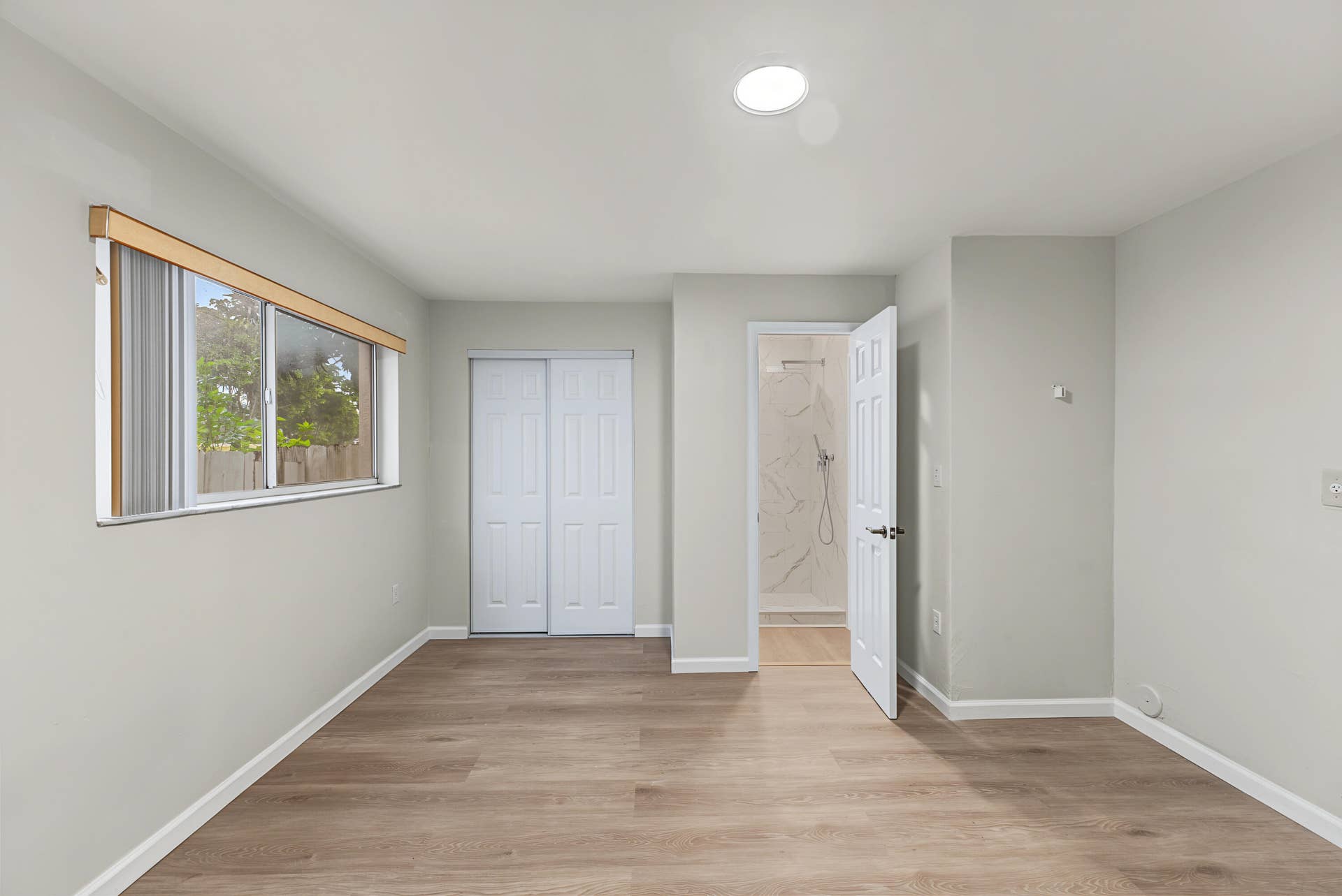 21109 NE 3RD Court, Miami, FL 33179 Neutral-toned interior featuring wood-finish flooring, a horizontal sliding window, dual-paneled closet doors, and recessed ceiling lighting