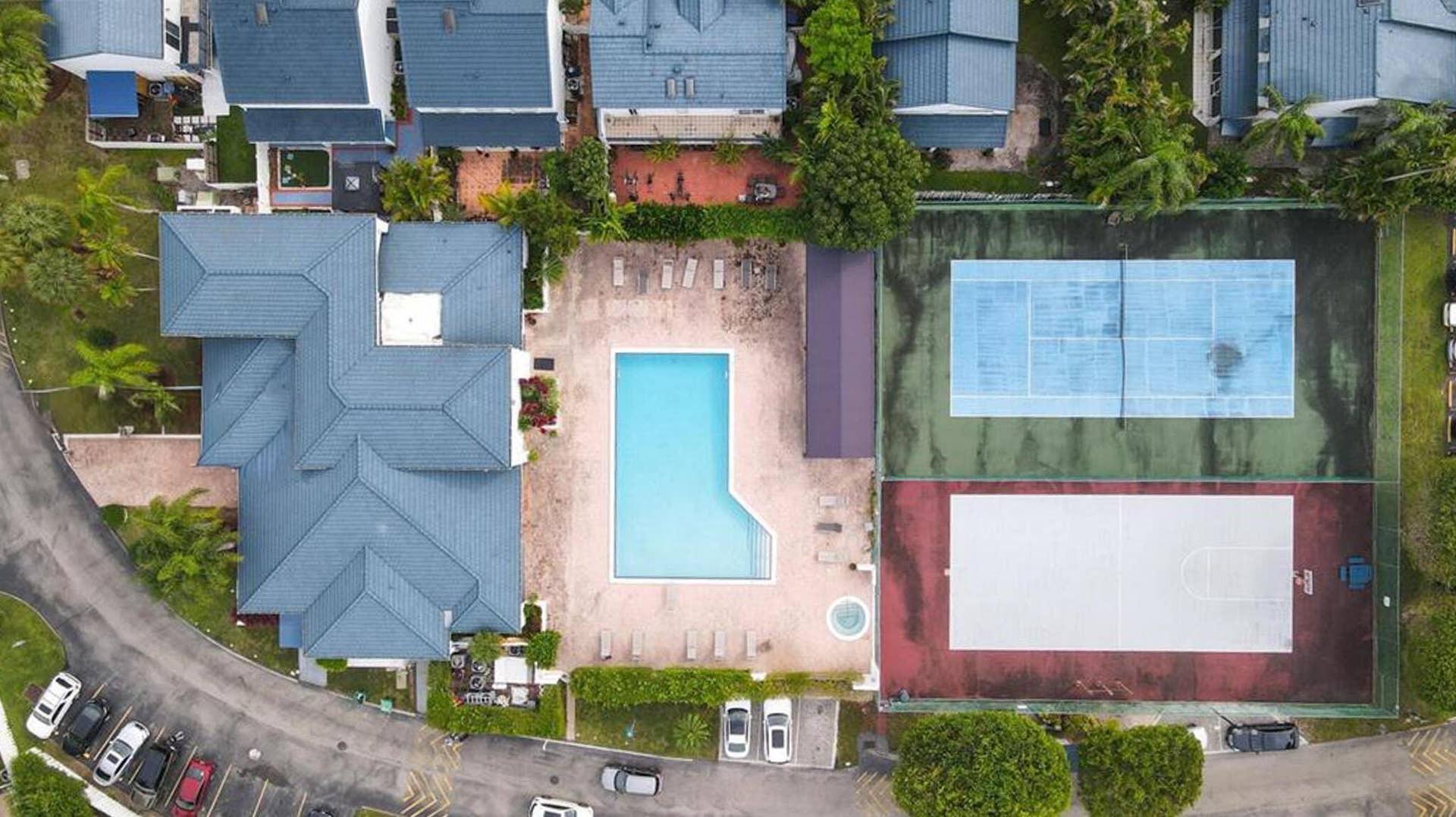 21109 NE 3RD Court, Miami, FL 33179 Aerial perspective featuring a swimming pool, spa, fenced tennis court, and outdoor basketball court