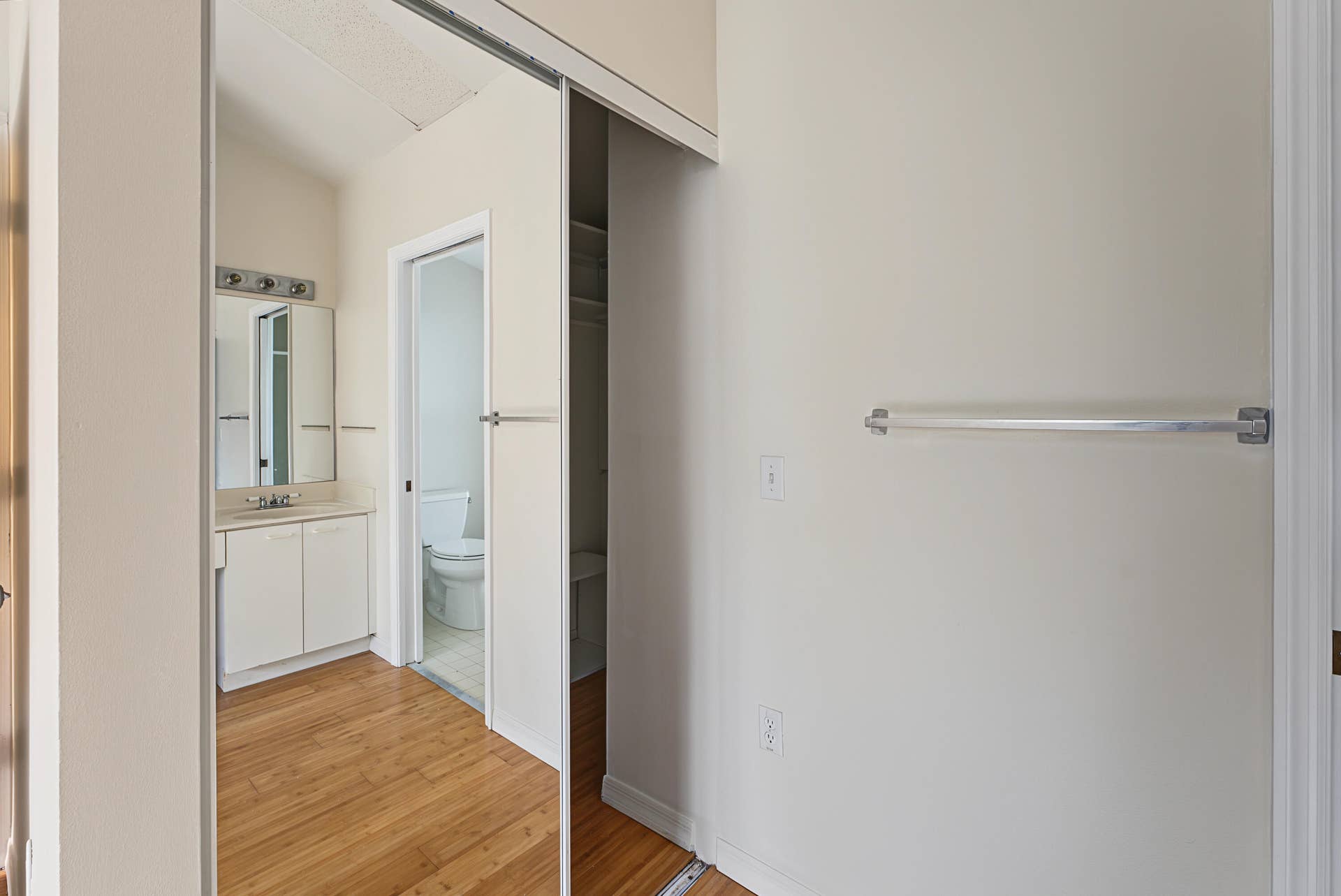 21109 NE 3RD Court, Miami, FL 33179 Sliding mirrored closet doors, wood-finish flooring, white vanity with countertop sink, and wall-mounted metal towel rack