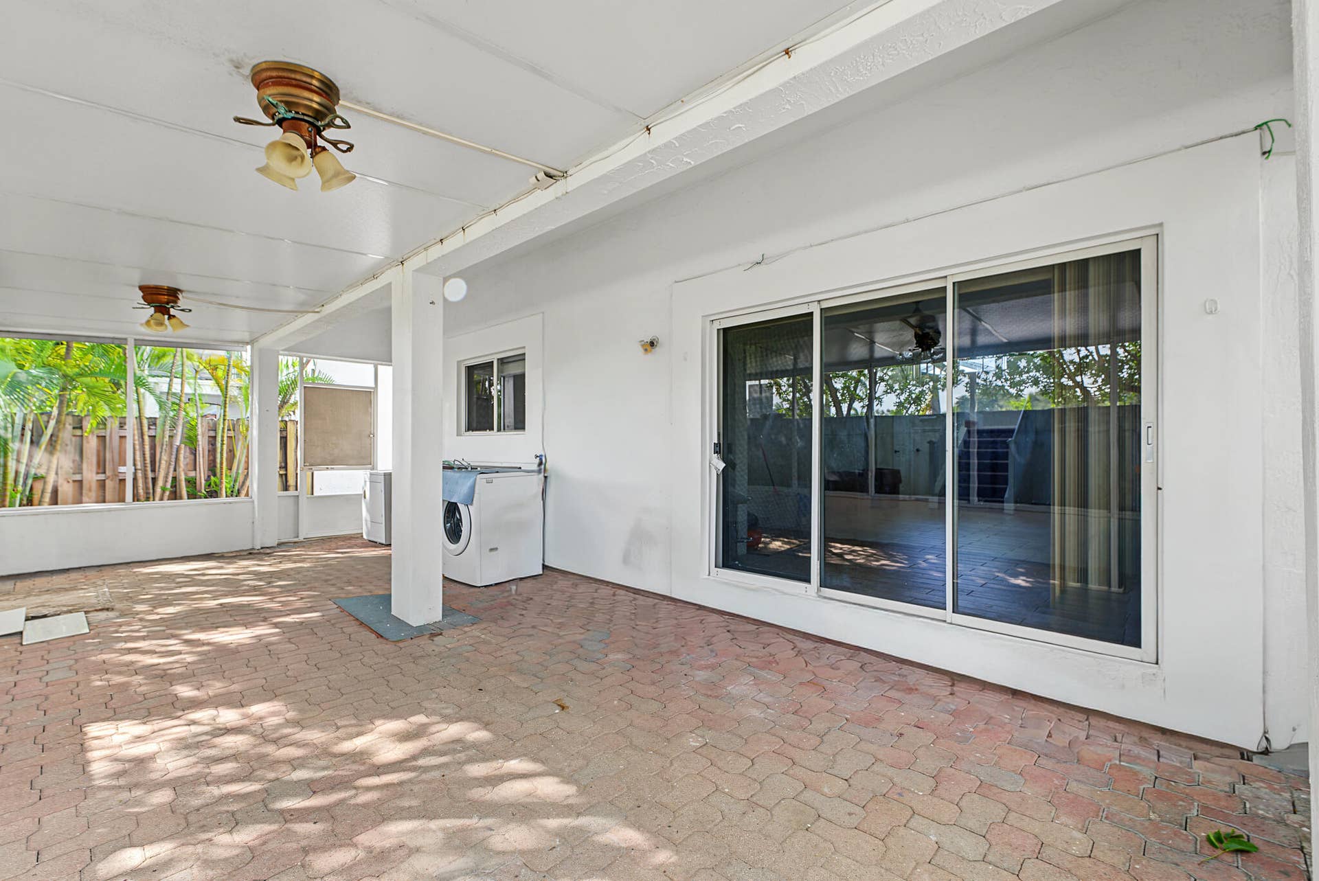 21109 NE 3RD Court, Miami, FL 33179 Covered patio featuring paver flooring, dual ceiling-mounted light fixtures, and sliding glass doors