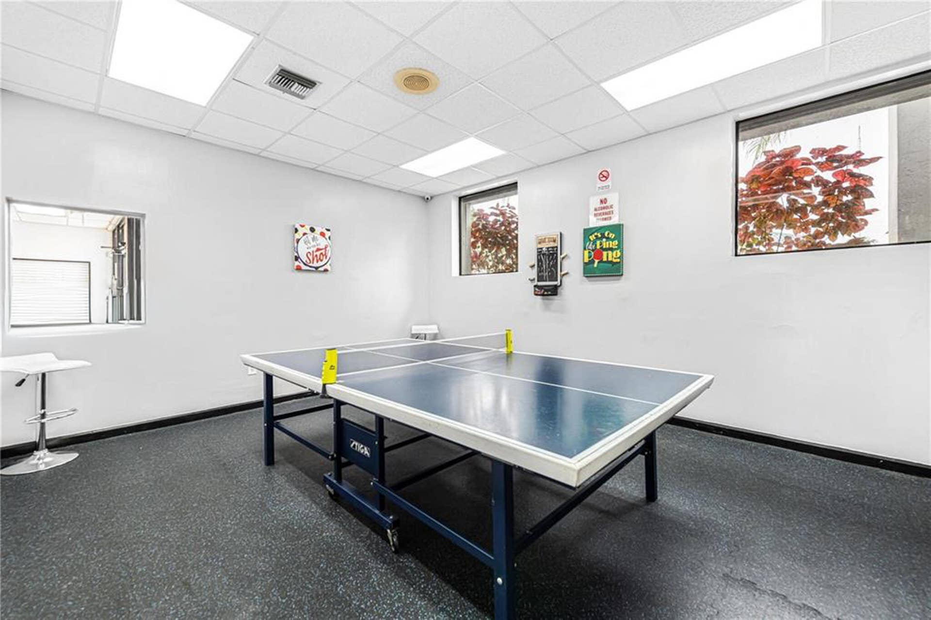 21109 NE 3RD Court, Miami, FL 33179 Interior space featuring a drop ceiling with recessed panel lighting, multi-pane windows, and durable rubber flooring