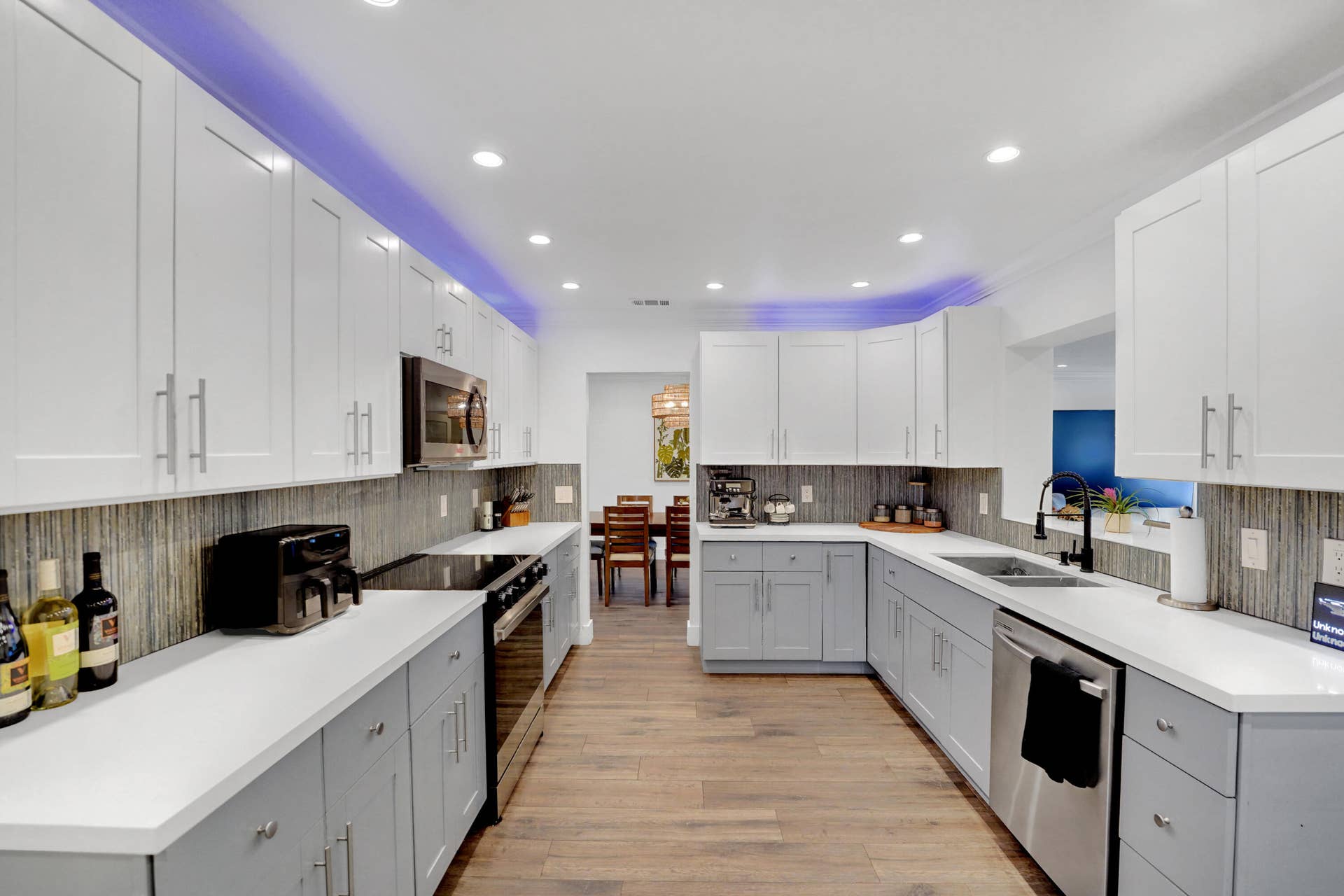 380 NW 35TH Court, Oakland Park, FL 33309 Kitchen featuring two-tone shaker-style cabinetry, quartz countertops, integrated recessed lighting, wood-finish flooring, and a textured backsplash