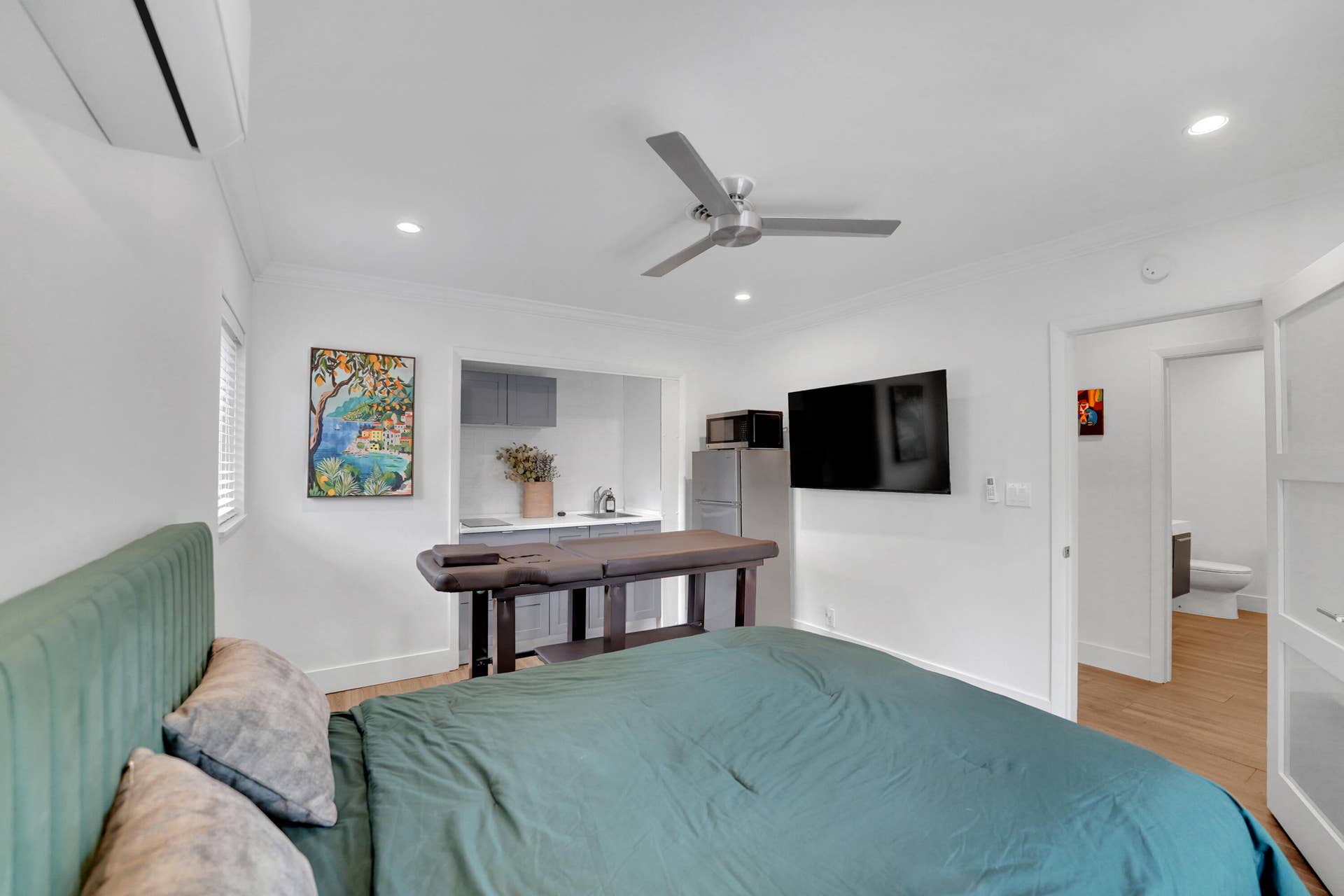 380 NW 35TH Court, Oakland Park, FL 33309 Interior space featuring recessed lighting, a ceiling fan, wood-finish flooring, a wall-mounted climate control unit, and a built-in kitchenette area with cabinetry and a sink