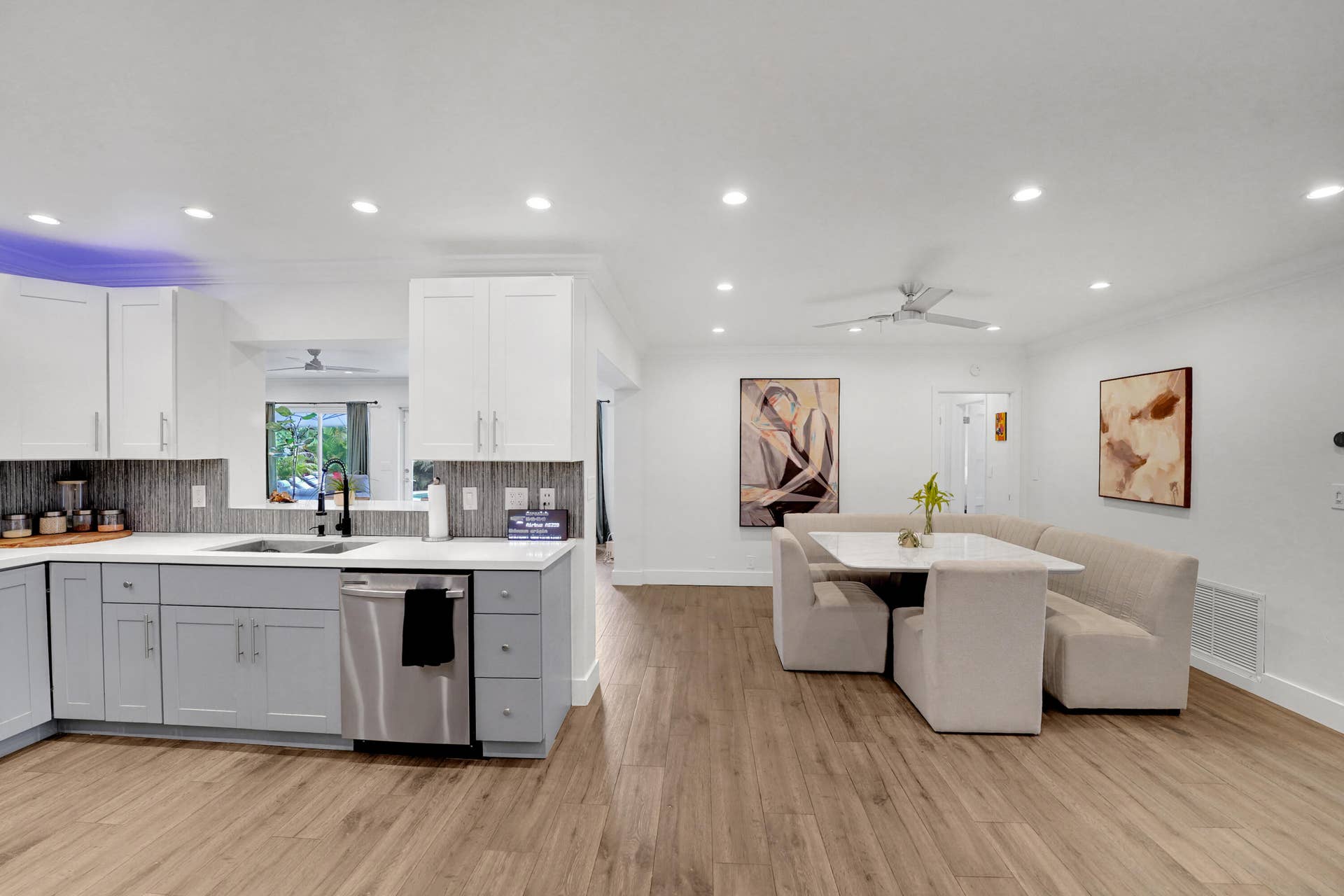 380 NW 35TH Court, Oakland Park, FL 33309 Kitchen featuring white upper cabinetry, grey base cabinetry, light-toned stone-finish countertops, subway tile backsplash, and recessed lighting throughout