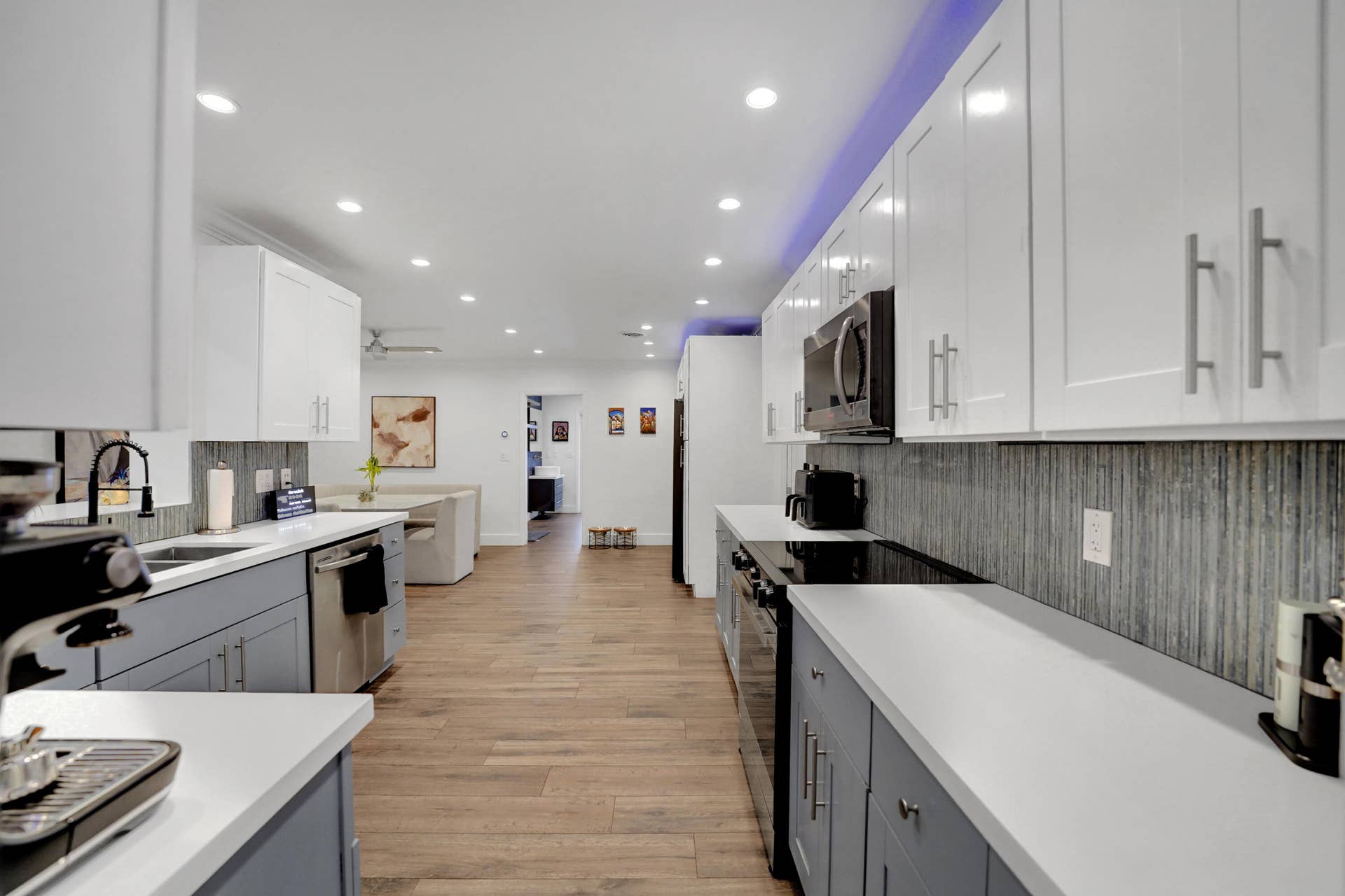 380 NW 35TH Court, Oakland Park, FL 33309 Kitchen featuring white and gray shaker-style cabinetry, white countertops, textured vertical tile backsplash, wood-finish flooring, and recessed ceiling lighting