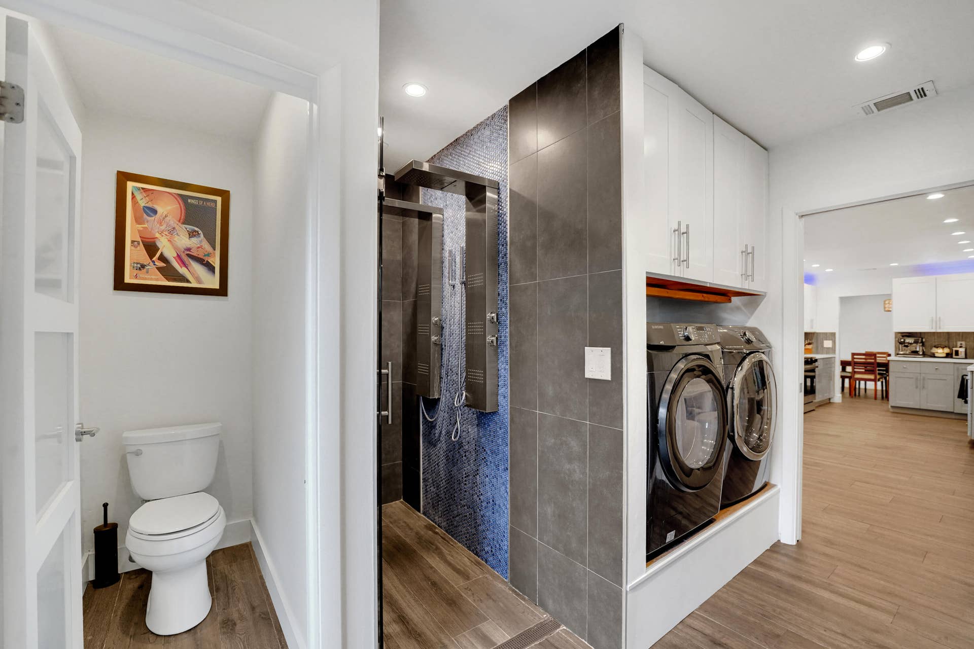 380 NW 35TH Court, Oakland Park, FL 33309 Shower stall with stainless steel multi-head panel and blue mosaic tile surround, built-in overhead cabinetry, and recessed lighting