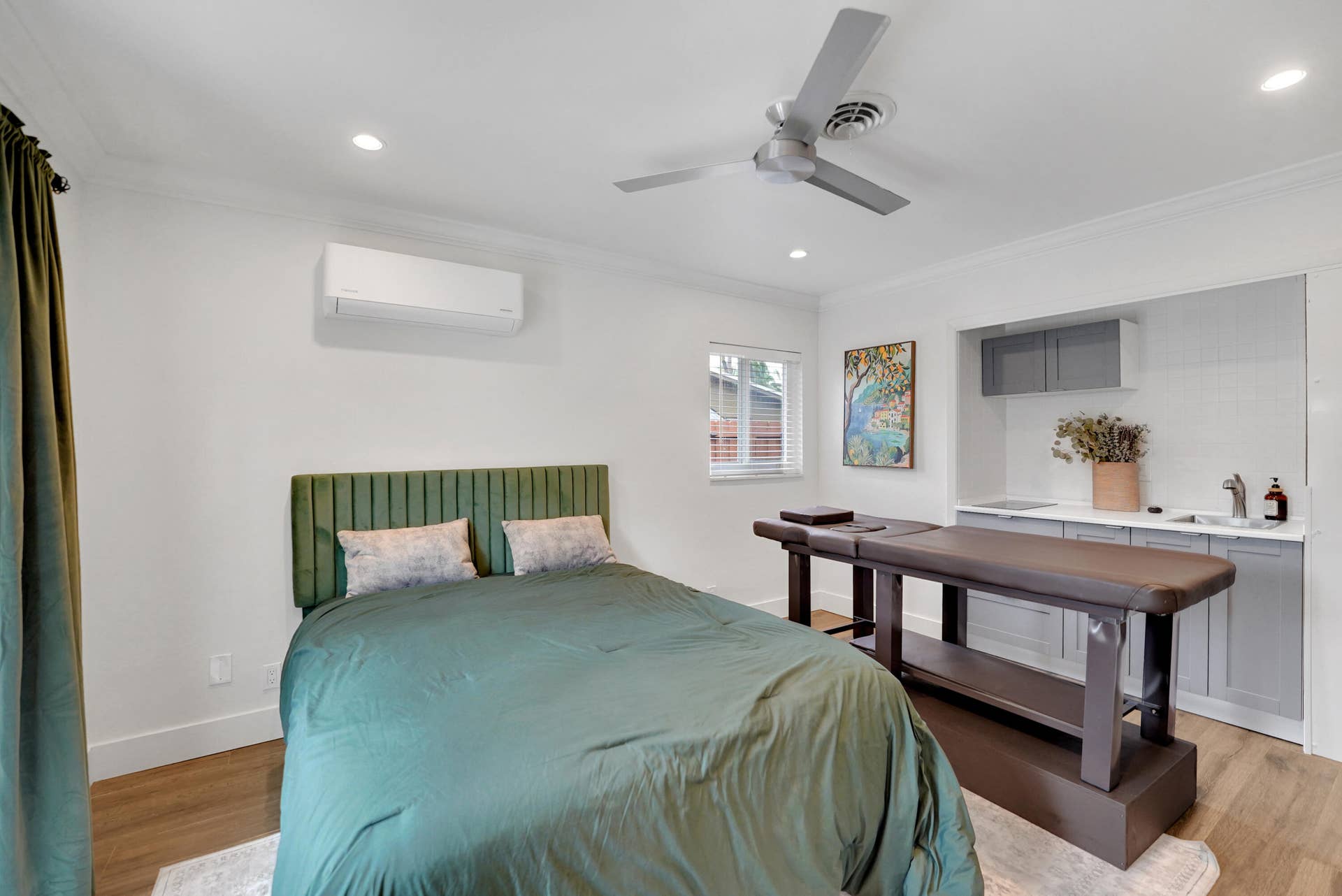 380 NW 35TH Court, Oakland Park, FL 33309 Room featuring wood-finish flooring, a ceiling fan, a wall-mounted climate control unit, and a built-in kitchenette with grey cabinetry and an integrated sink