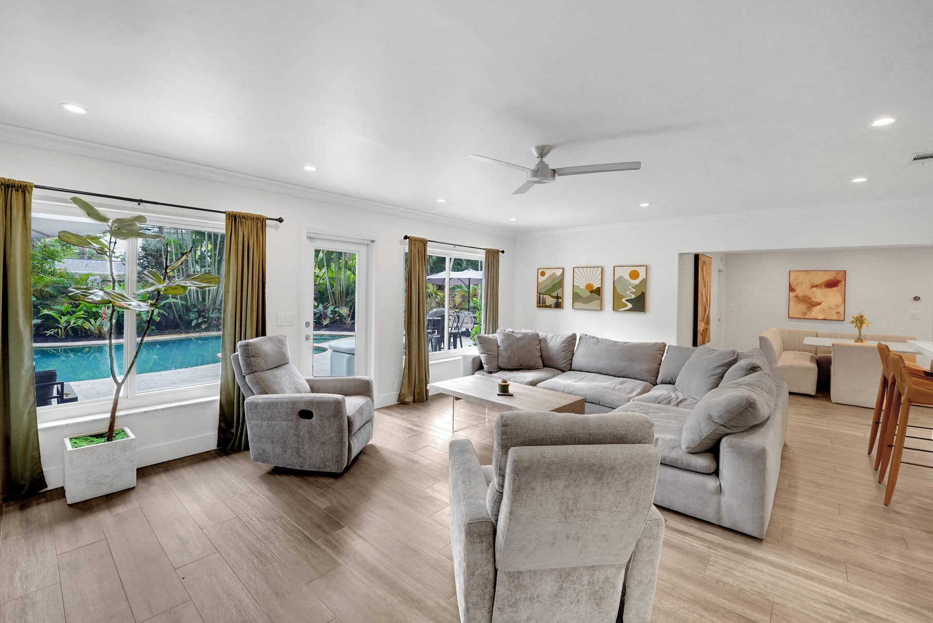 380 NW 35TH Court, Oakland Park, FL 33309 Open-concept living space featuring wood-finish flooring, recessed lighting, a ceiling fan, and large windows providing natural light